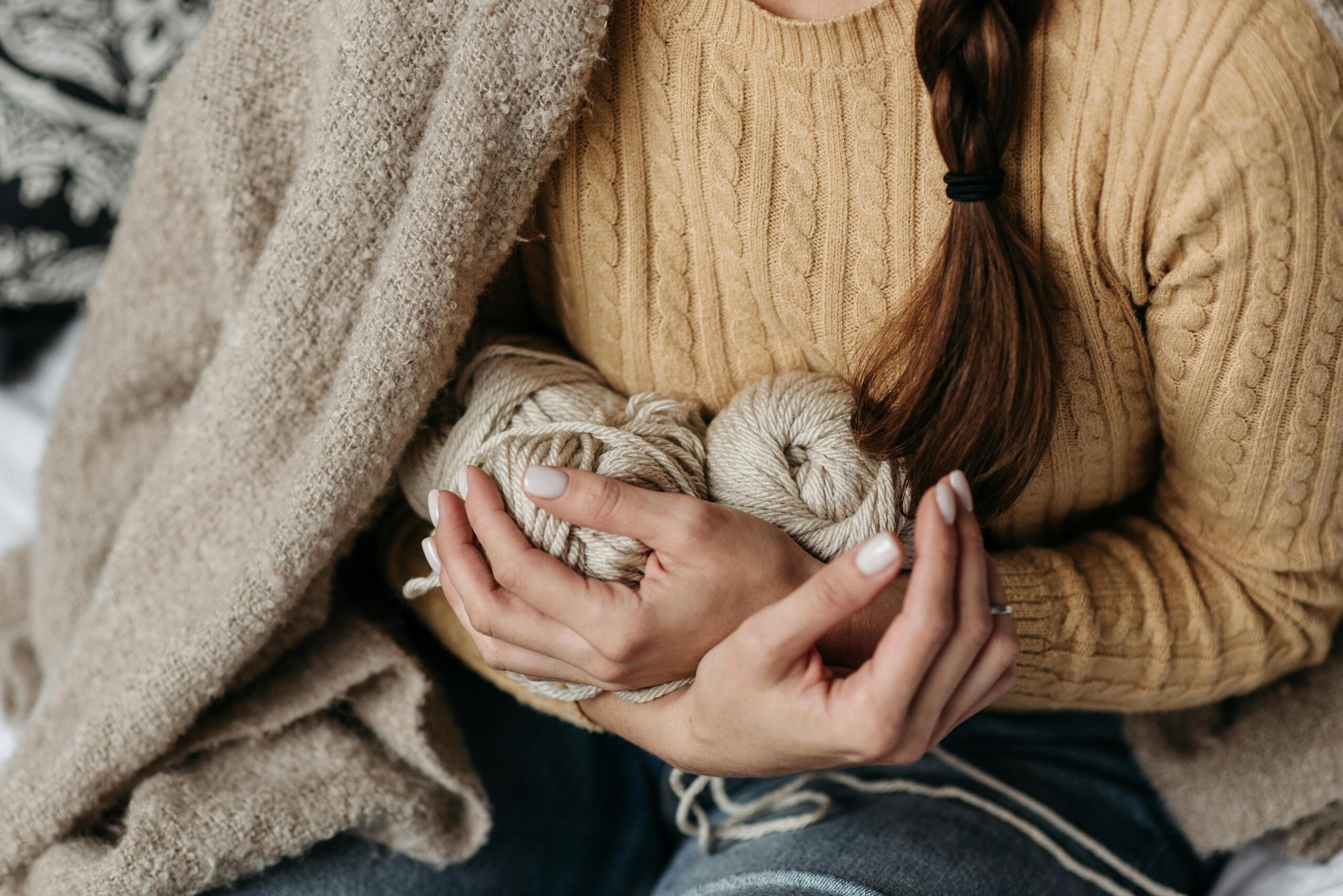 woman holding skeins of yarn to her chest