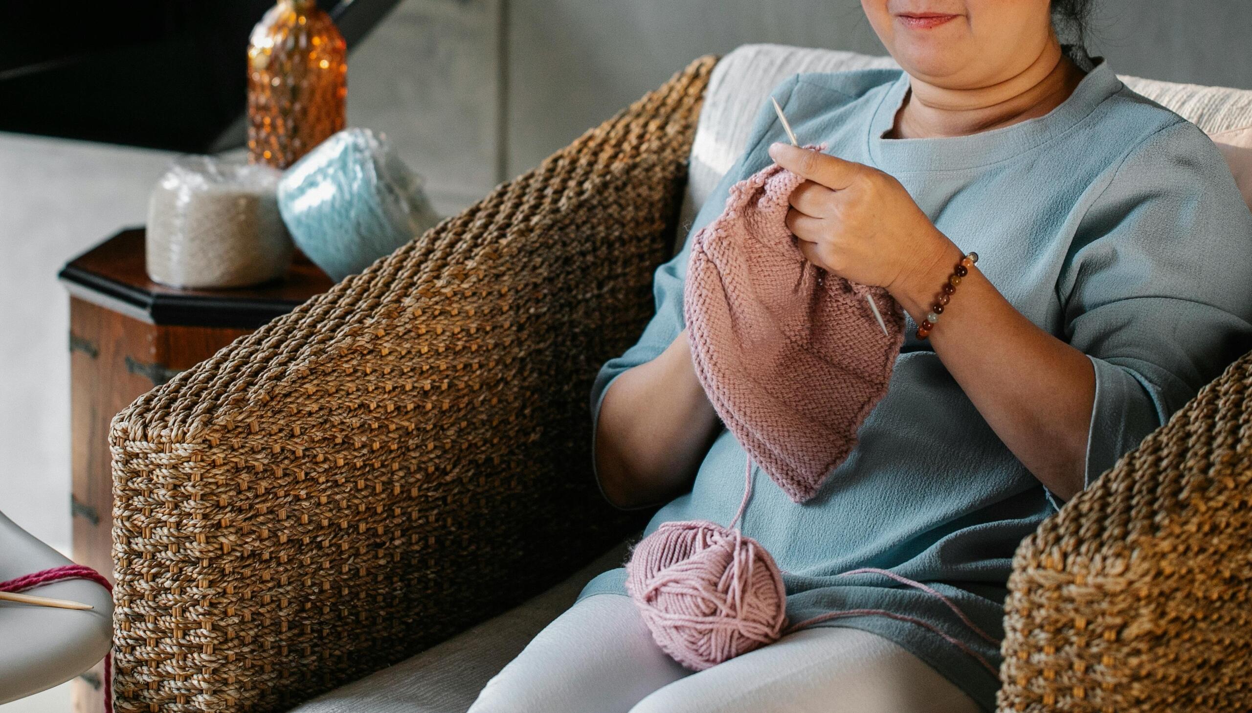 woman sitting in armchair knitting