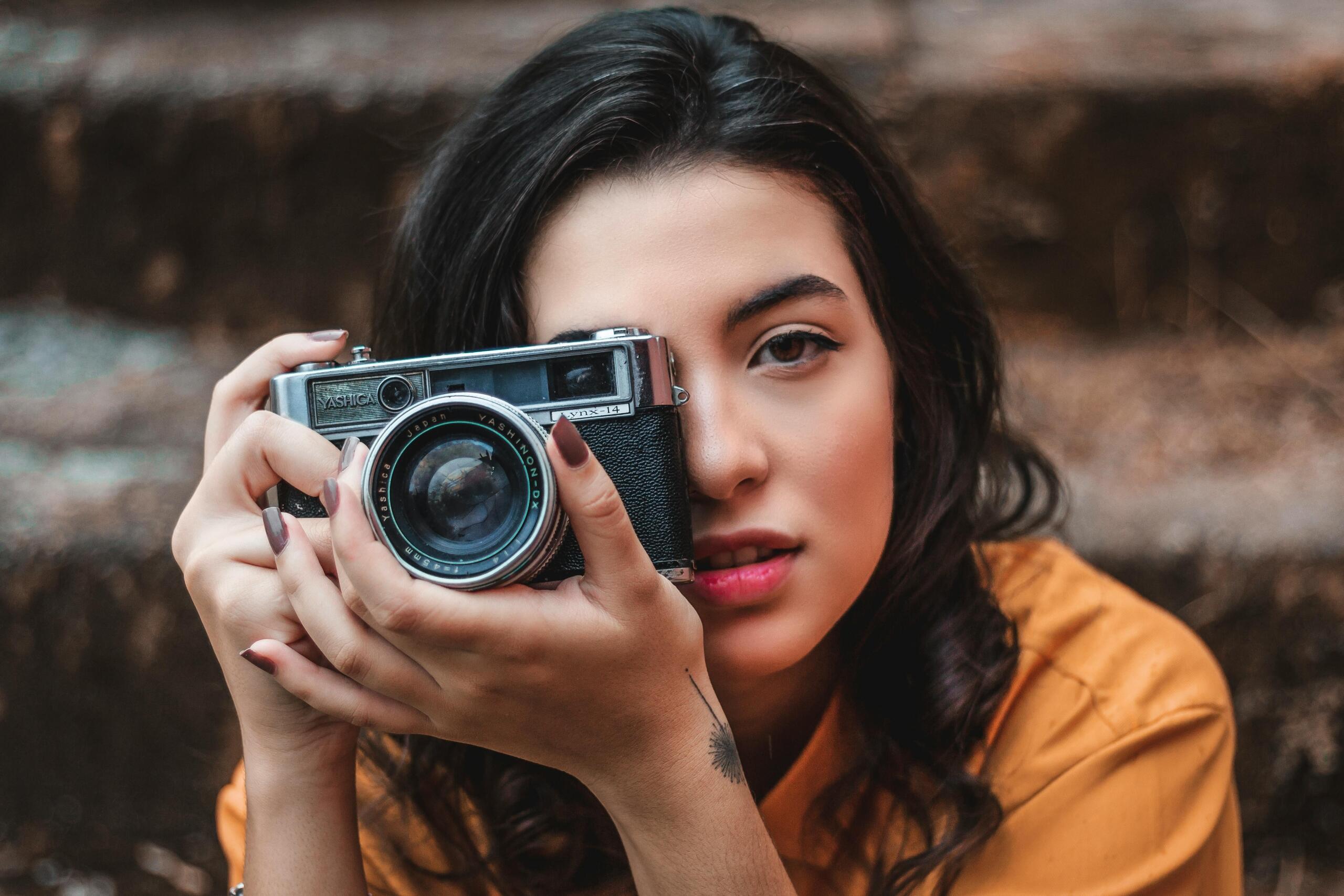 image of a photographer holding a camera up to her eye