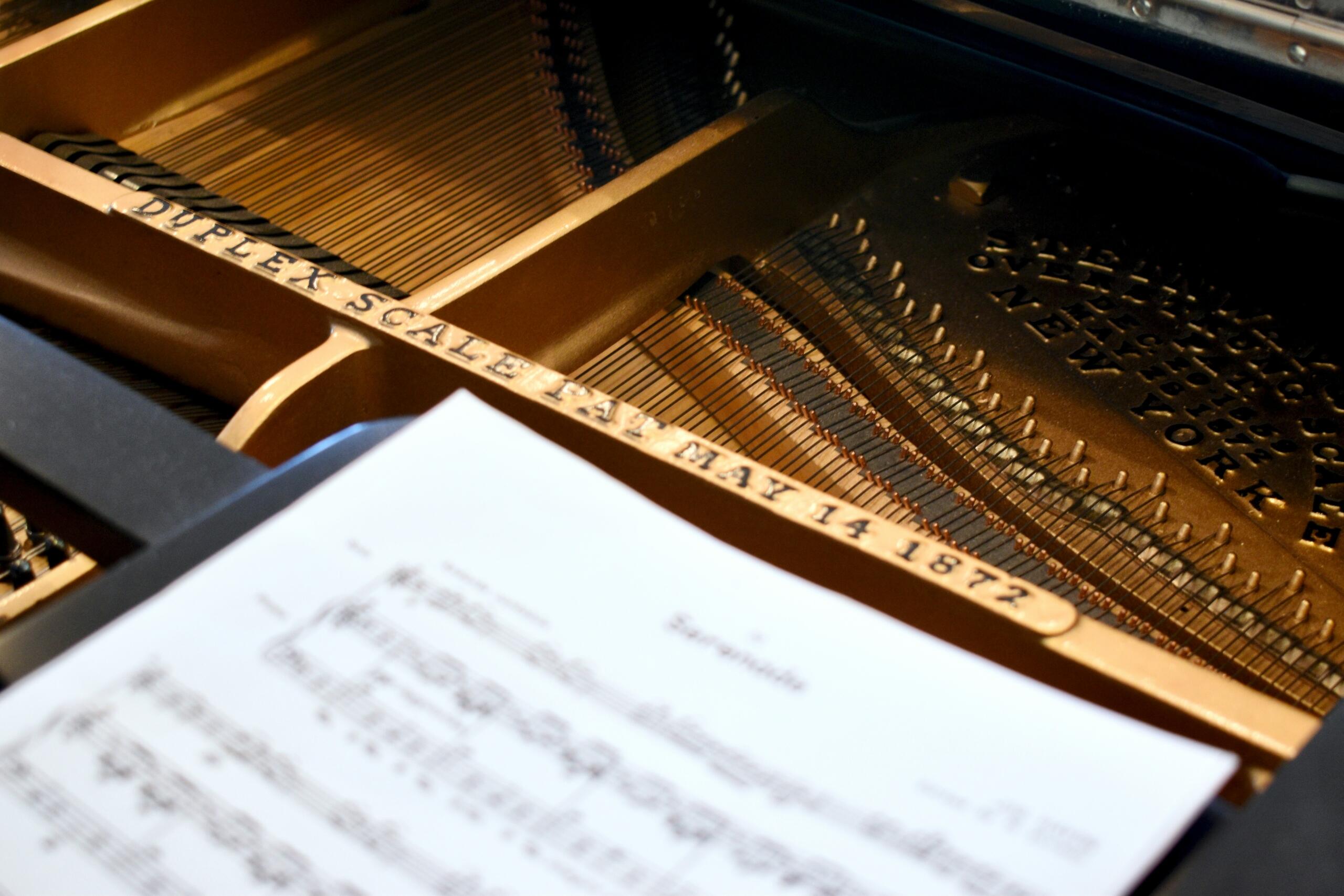 sheet music placed on top of an open piano