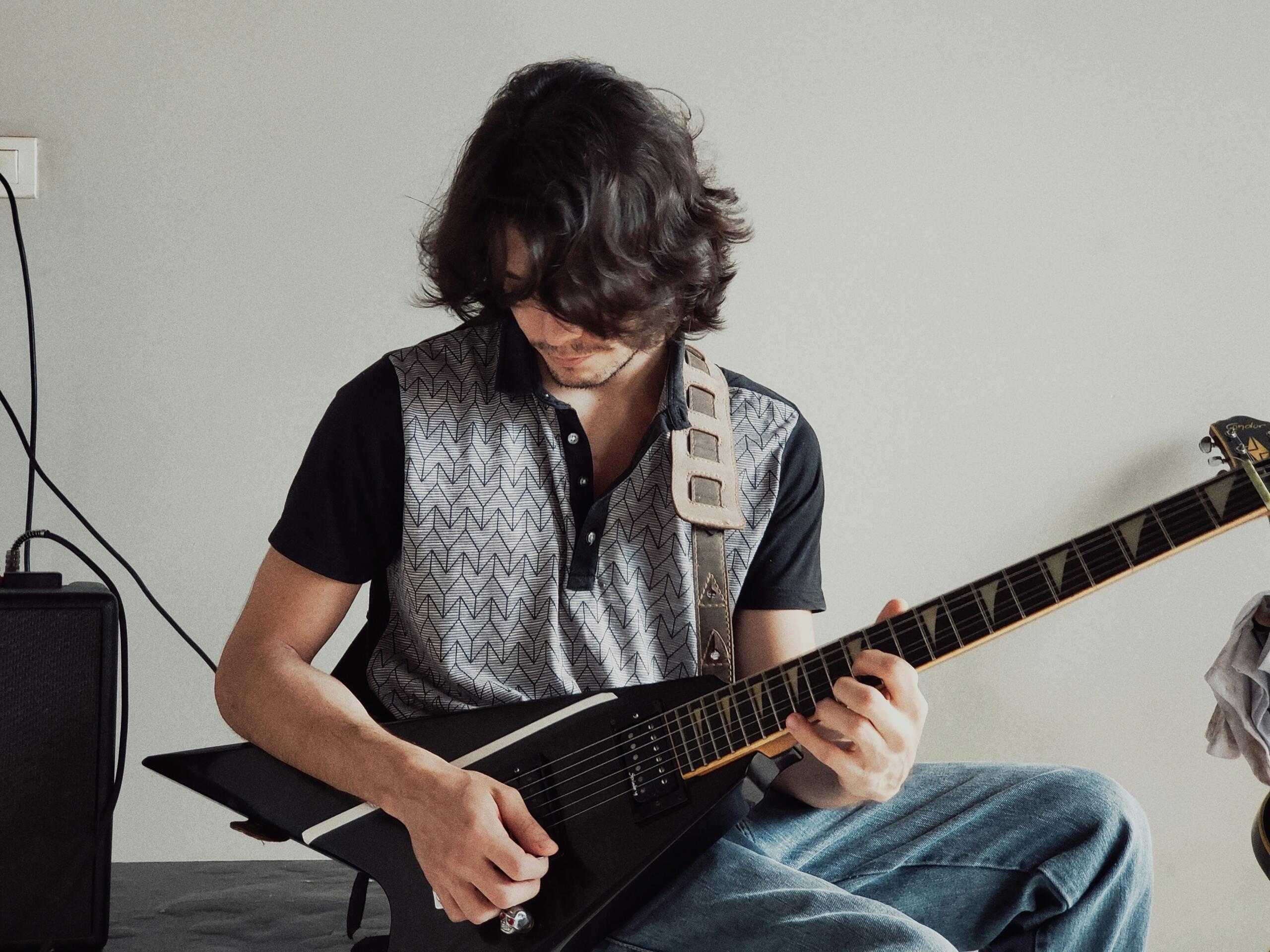 Man playing a black guitar