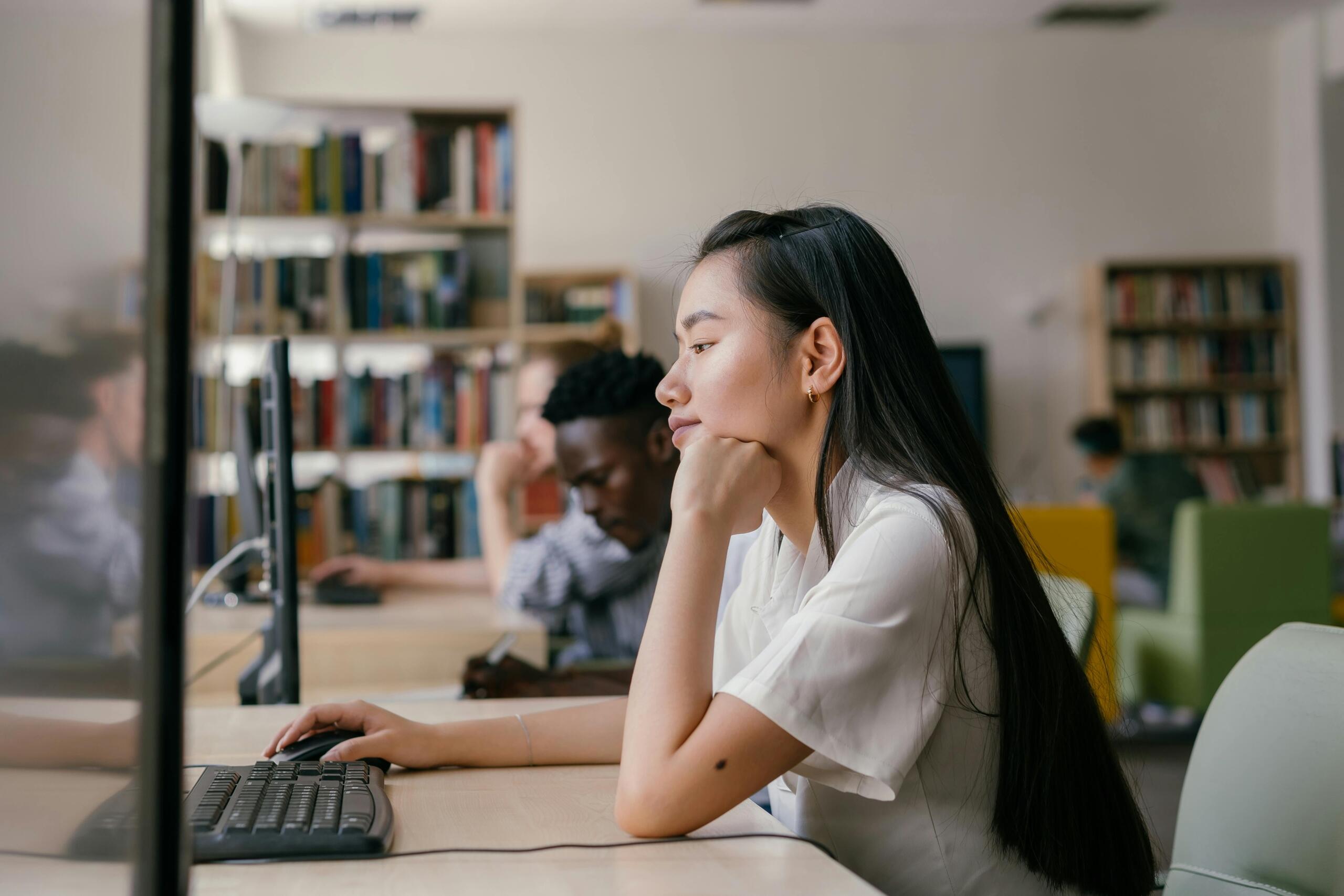 students working on desktop computers in a library
