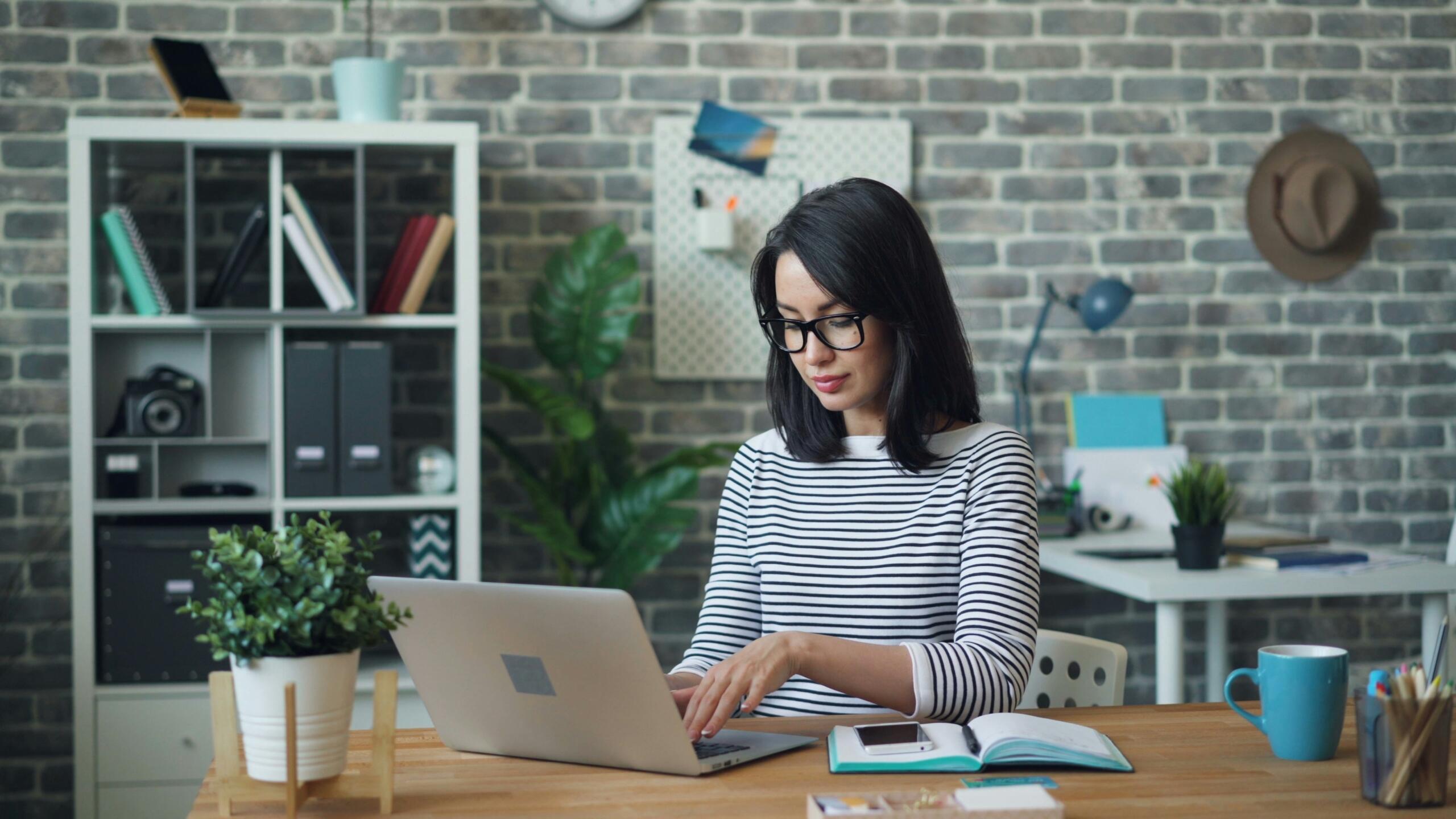 A professional-looking woman works at her laptop. 