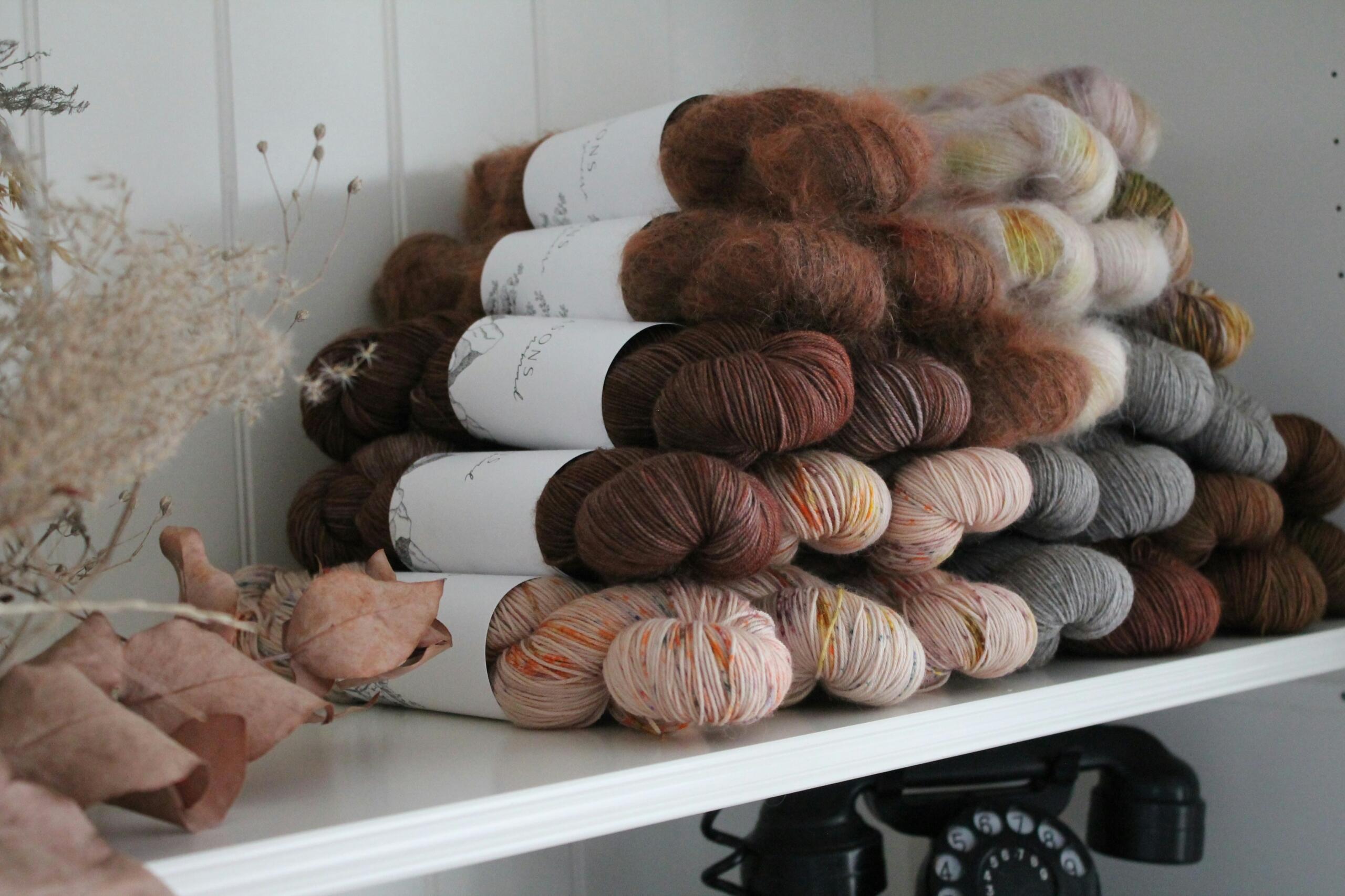 skeins of wool arra,nge neatly on a shelf