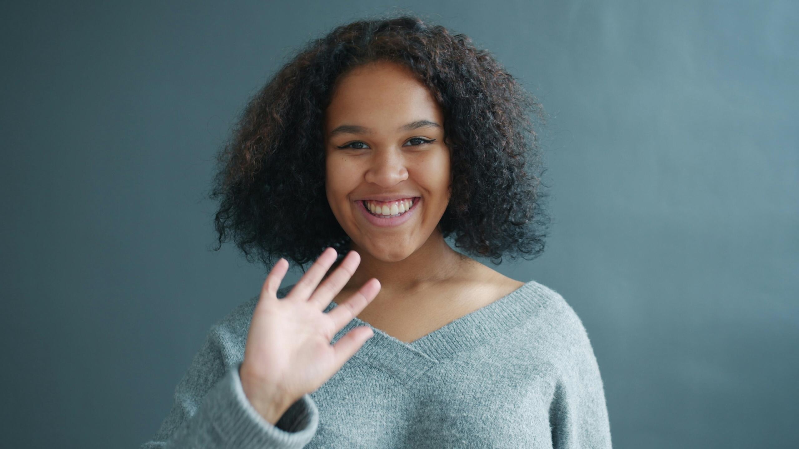 a woman waving at the camera
