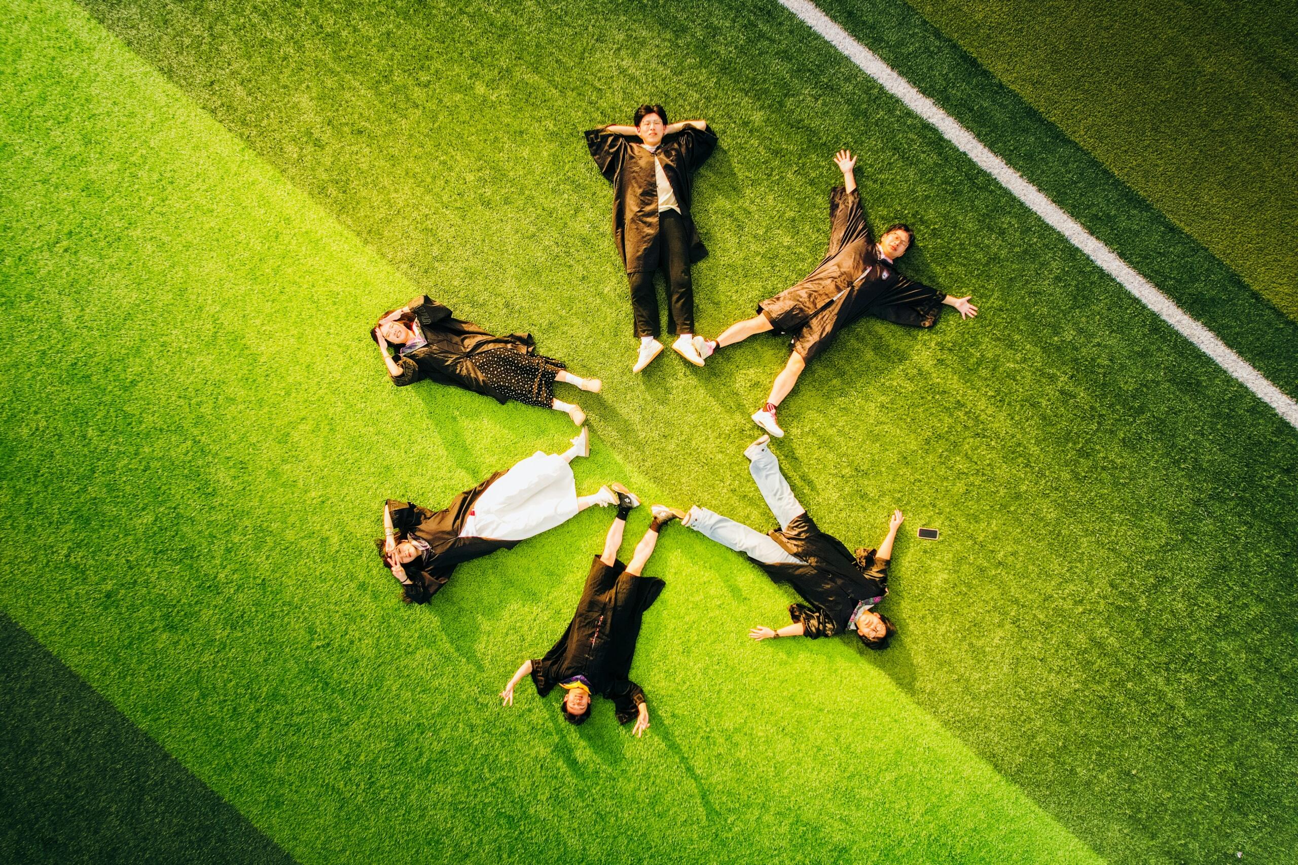 A bird's eye view of children making a star on a playground. 