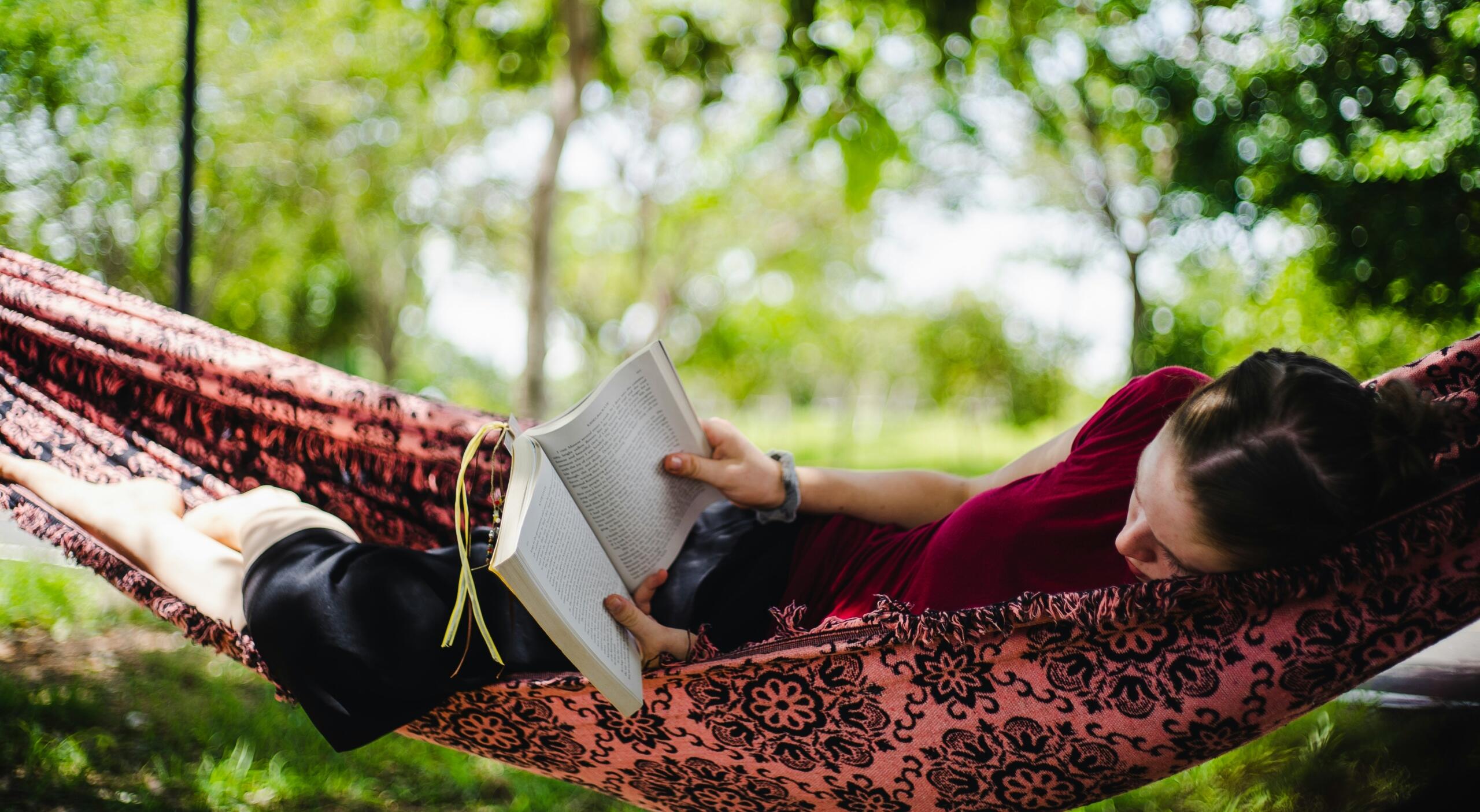 A girl reads in a hammock.