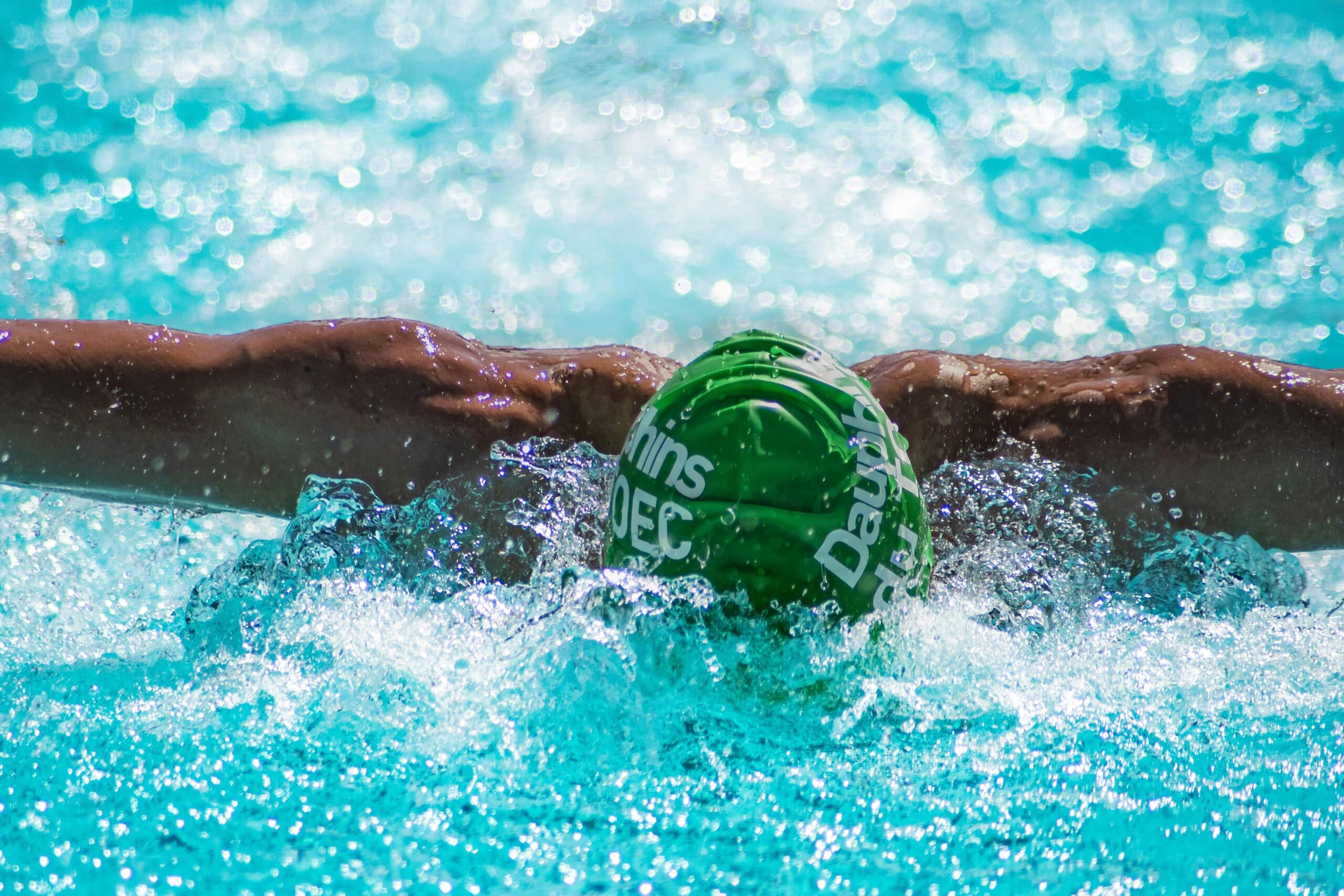 man in swimming pool wearing swimming cap