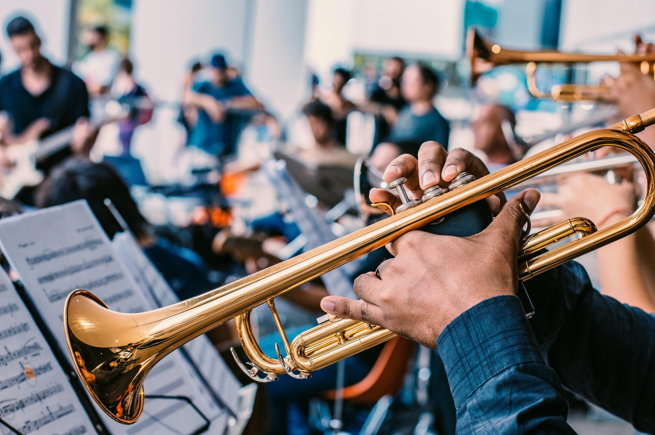 A trumpet player in the foreground of a music group.
