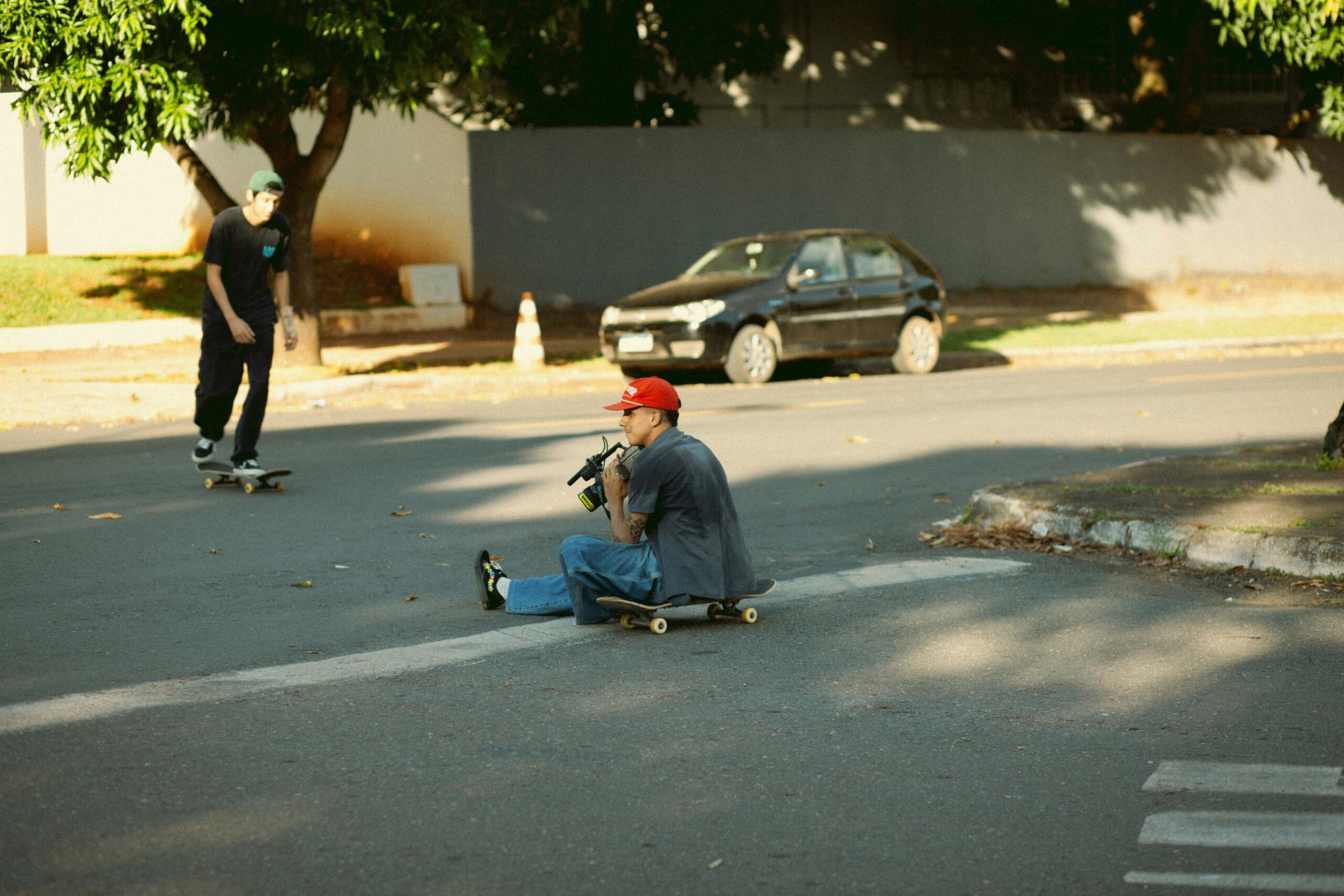 Boy sitting on a skateboard in the middle of the road.