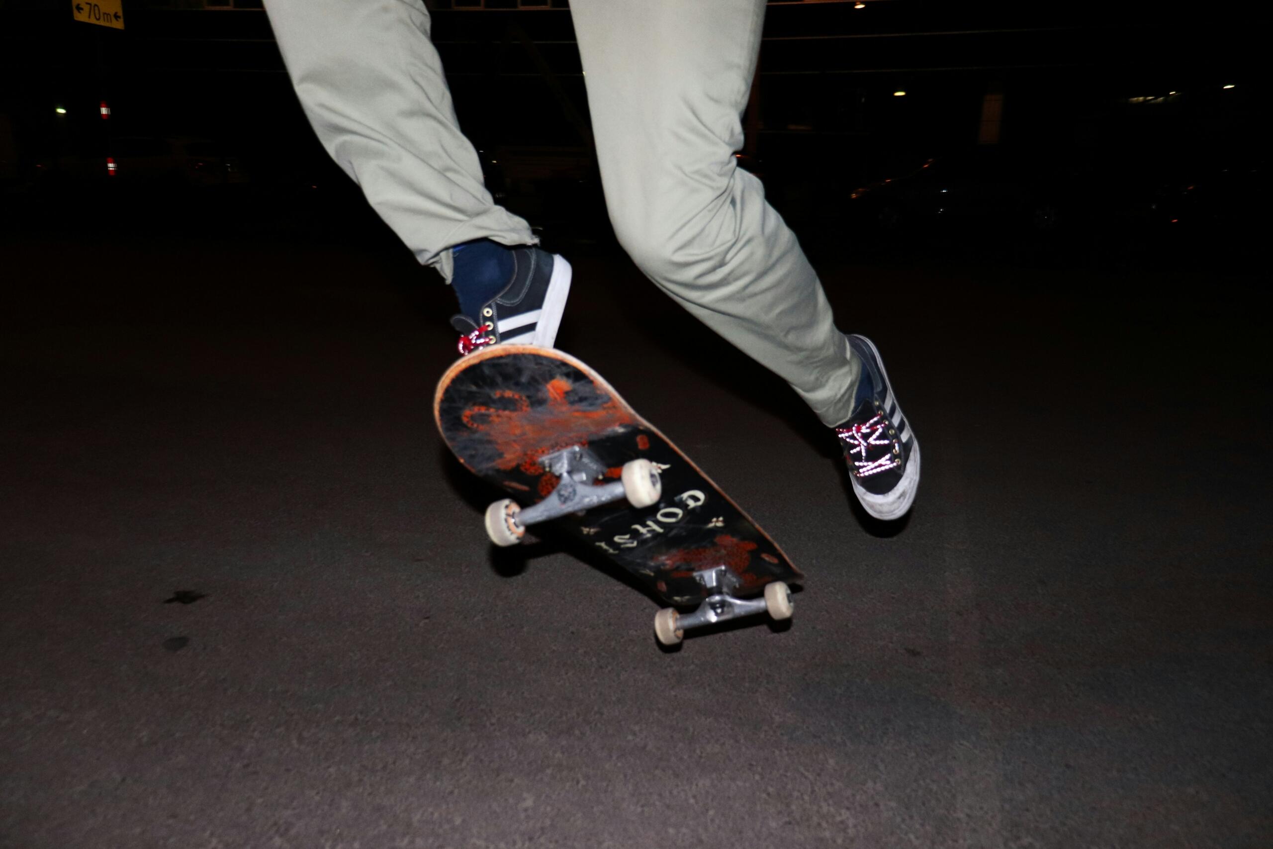 Left foot up in the air on the skateboard and right foot pushing forward