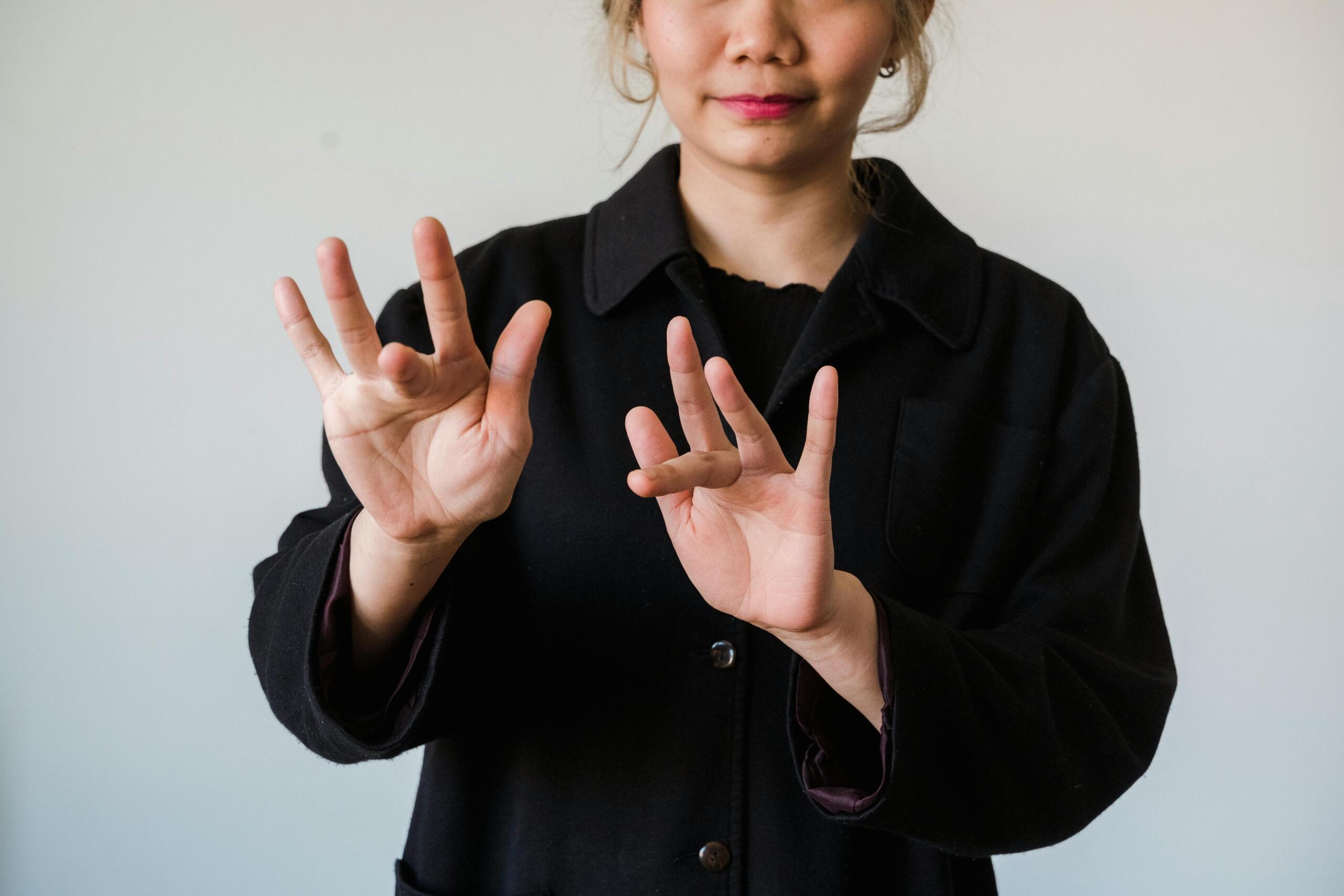 A studio image of hands using sign language.