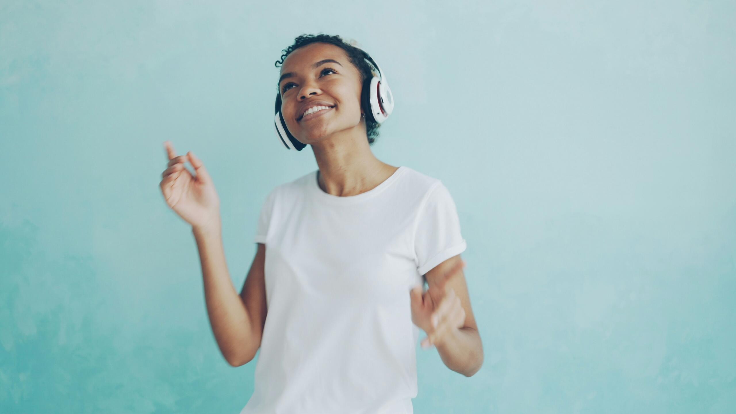 girl wearing headphones and dancing to music