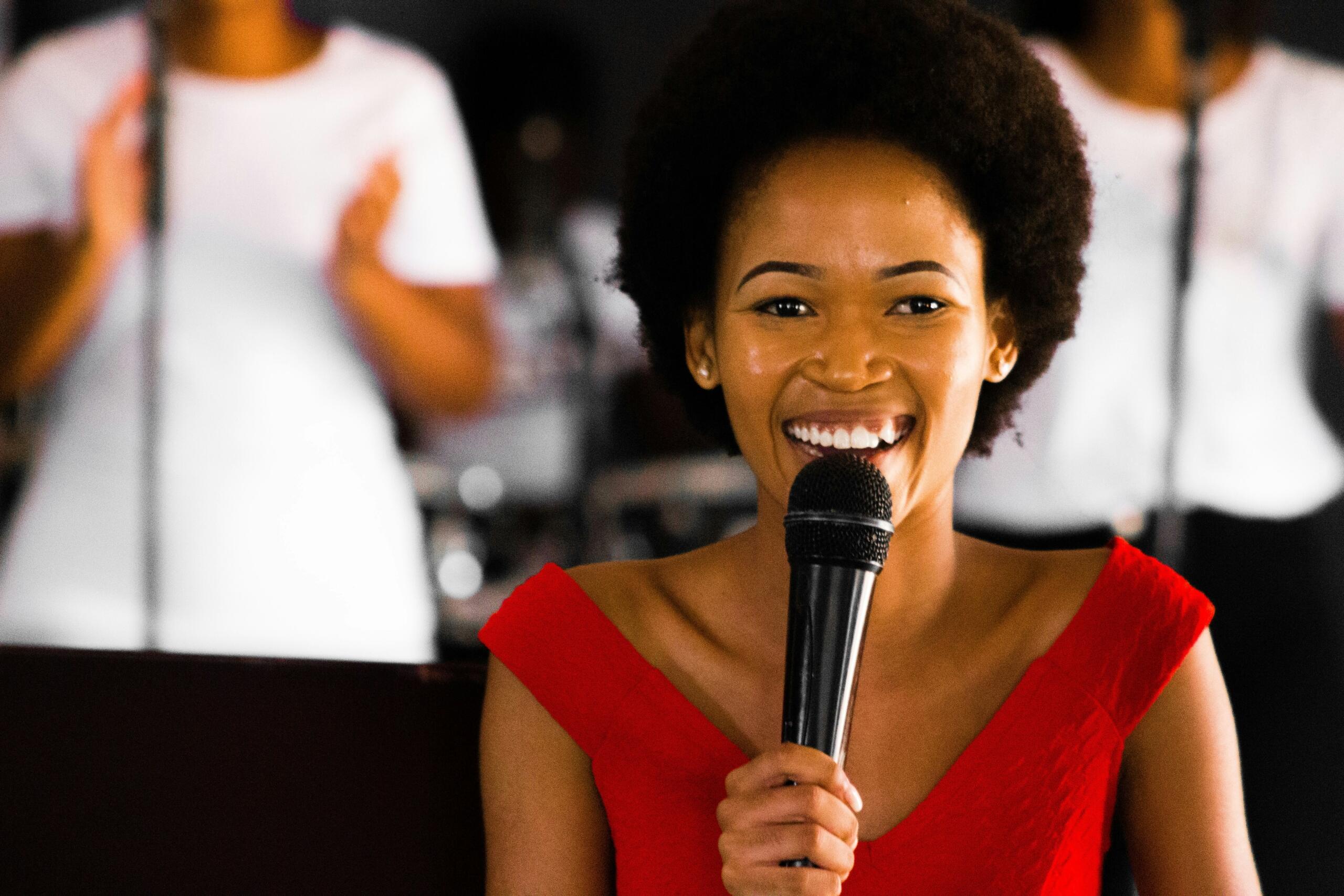 smiling woman on stage holding a microphone