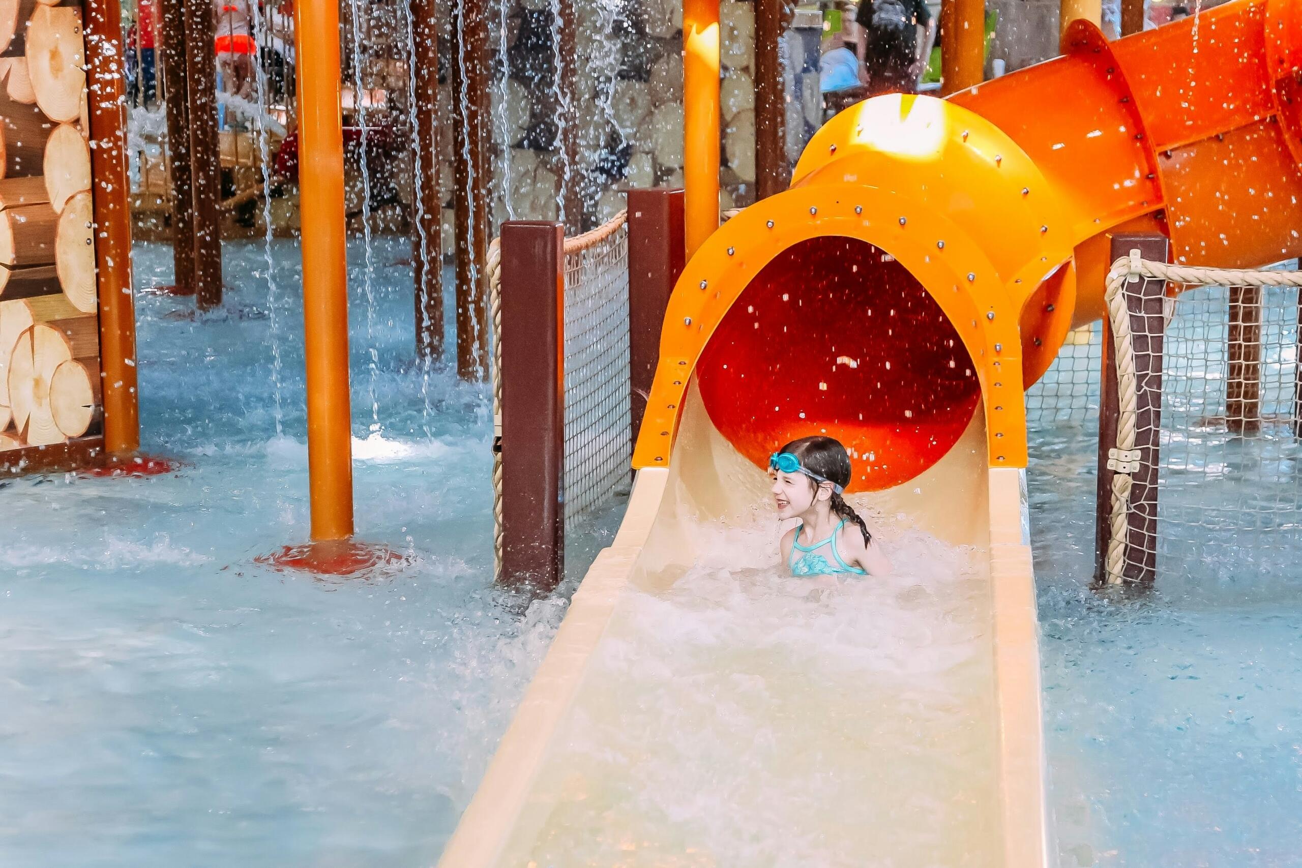 child sliding down a water slide at a water park