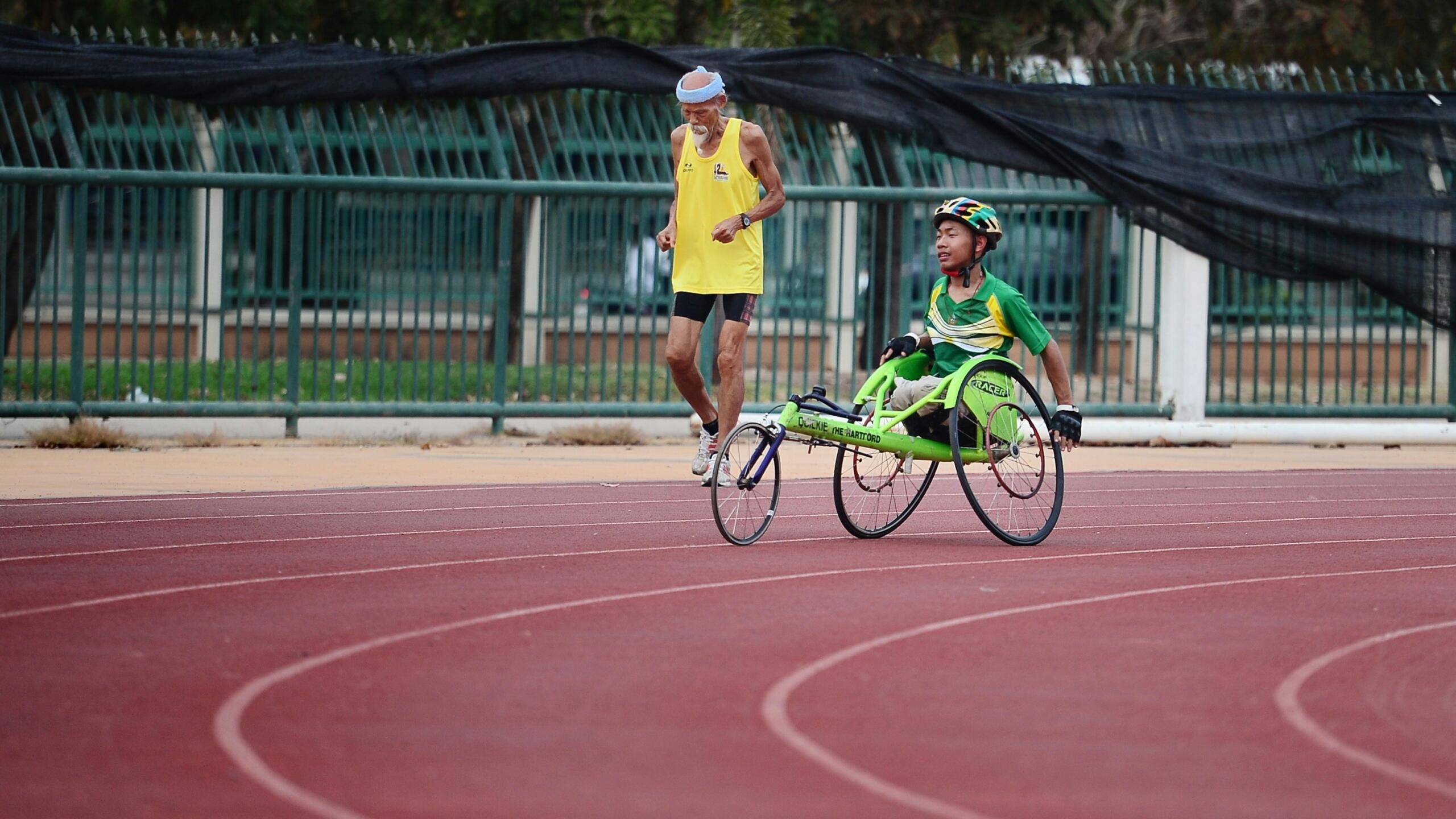 An image of an accompanied disabled cyclist competing.