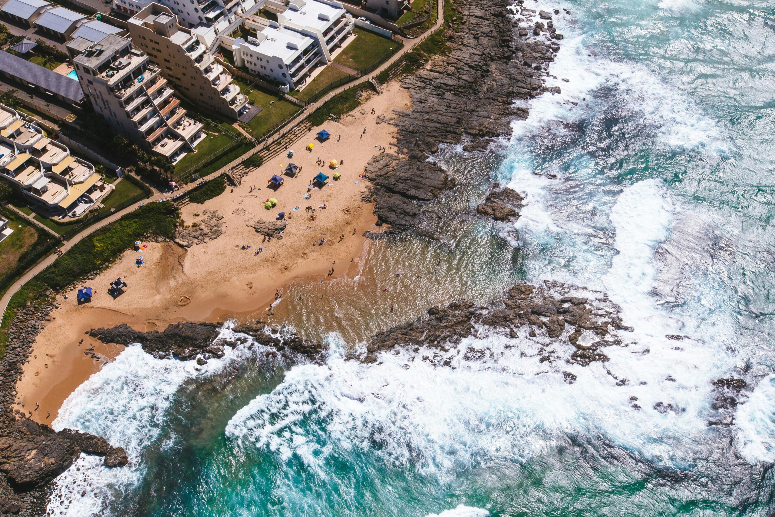 Aerial shot of a beachfront in Durban, with apartment blocks on the shore
