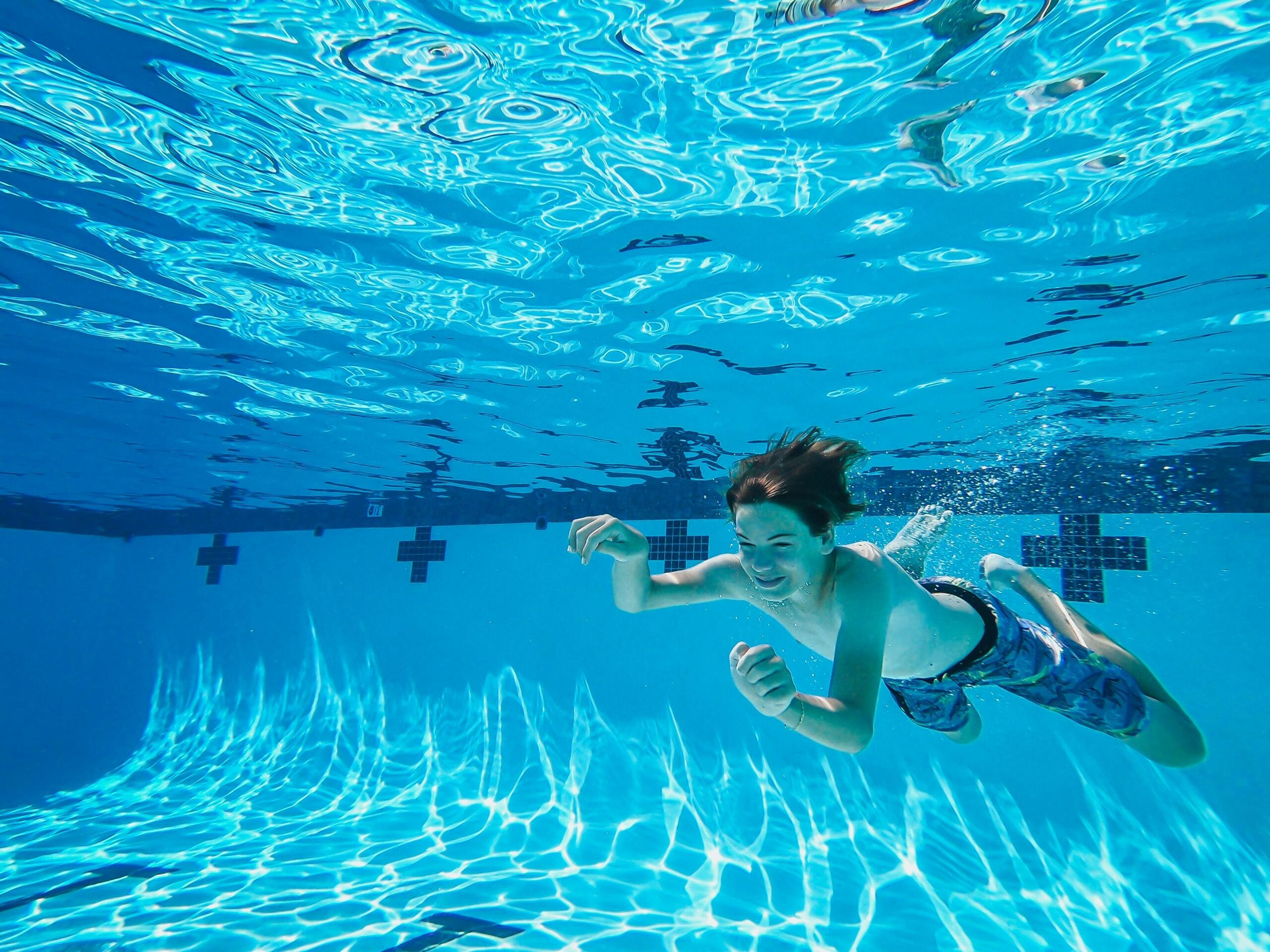 boy swimming underwater in a swimming pool