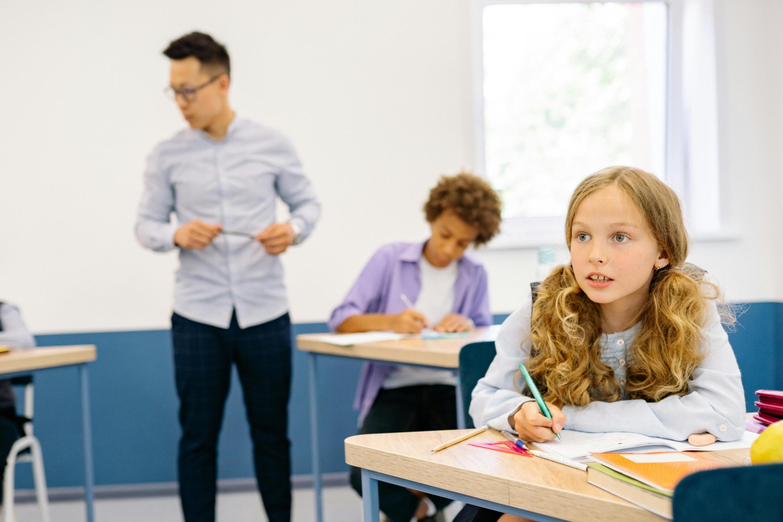 Teacher walking amongst students in Classroom