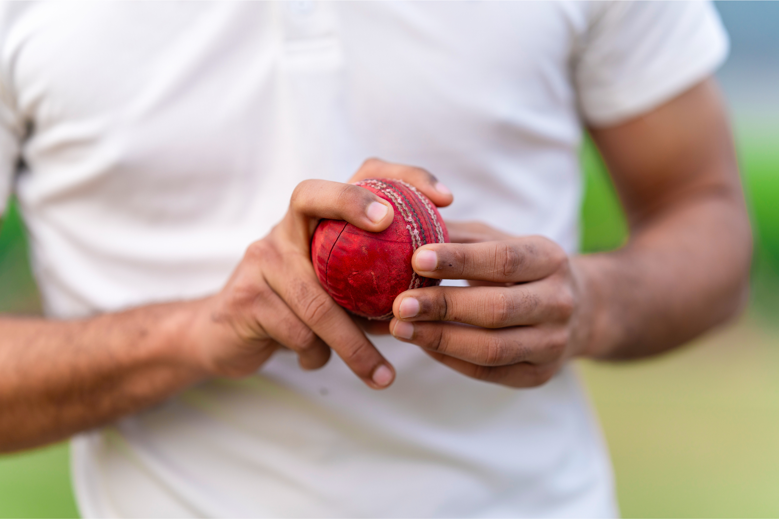cricket bowlet holding ball in his two hands preparing to bowl