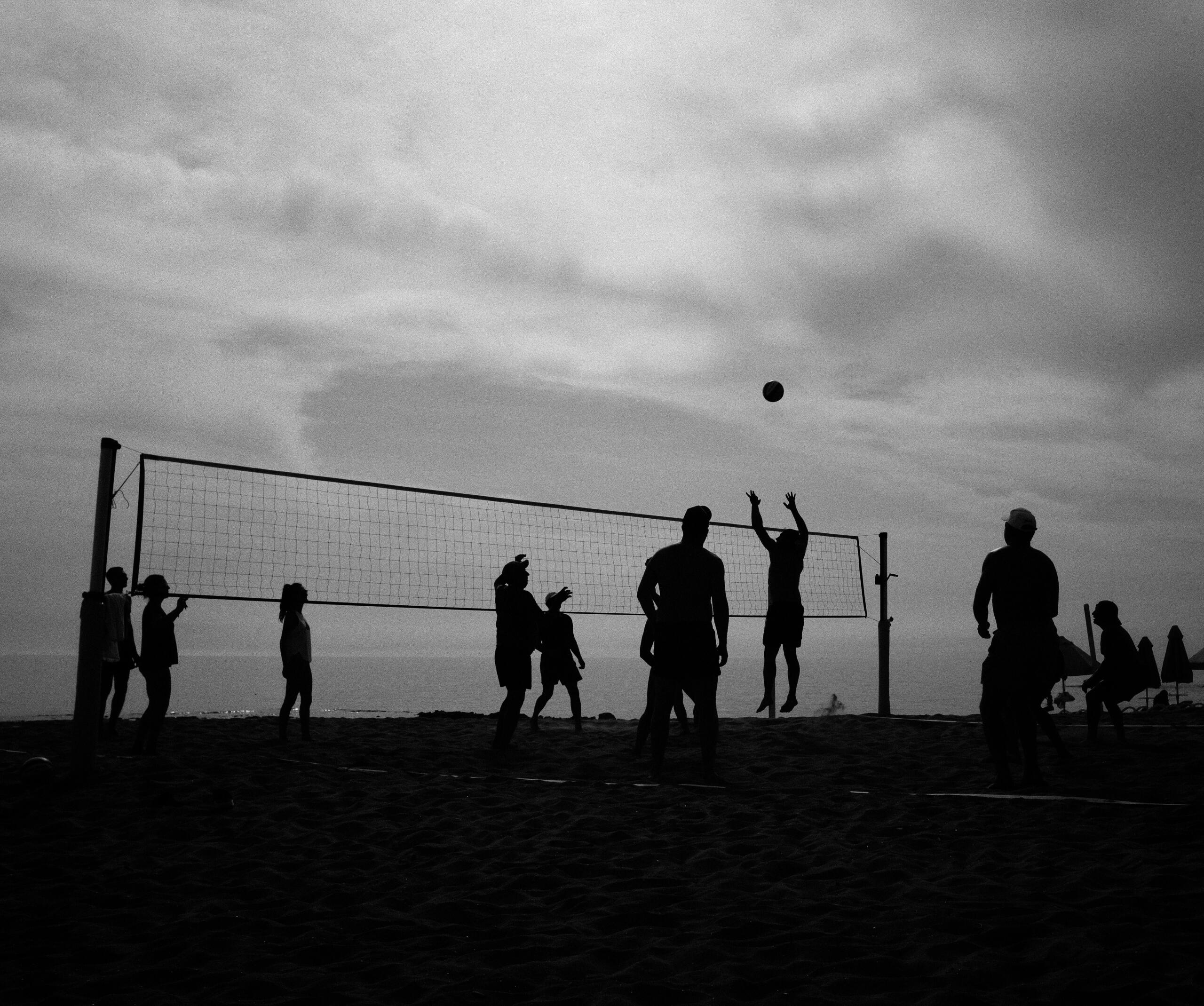 Volleyball teams playing in dark grey skies