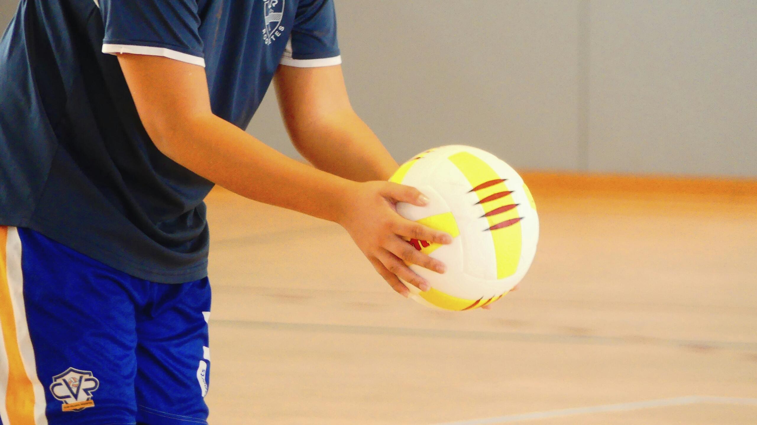 Two hands holding a volley ball