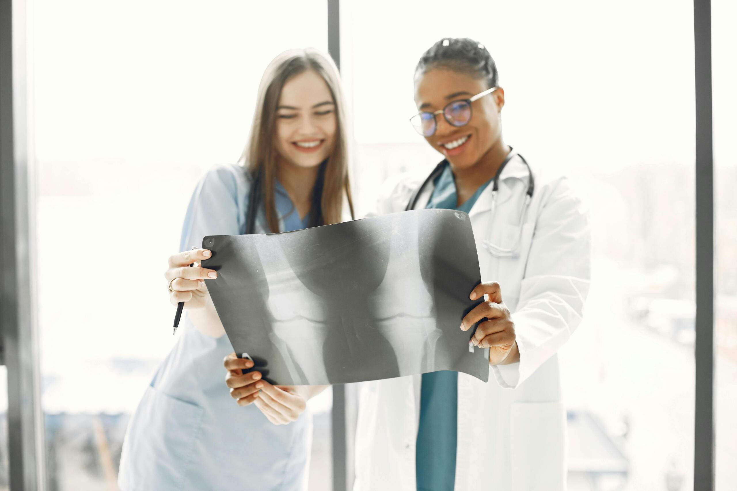 medical student and doctor wearing lab coat looking at x-rays