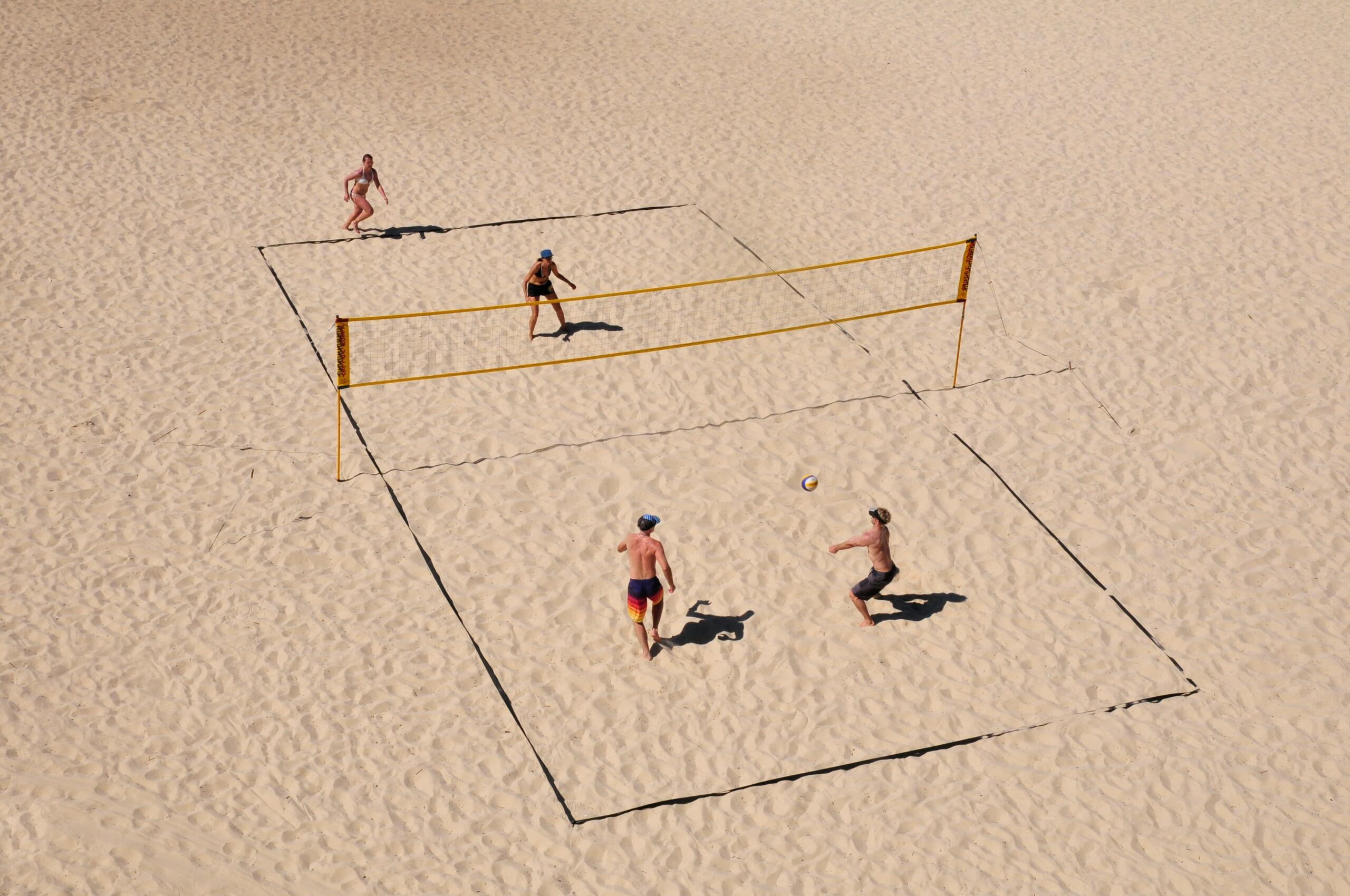 A team of four players playing beach volleyball