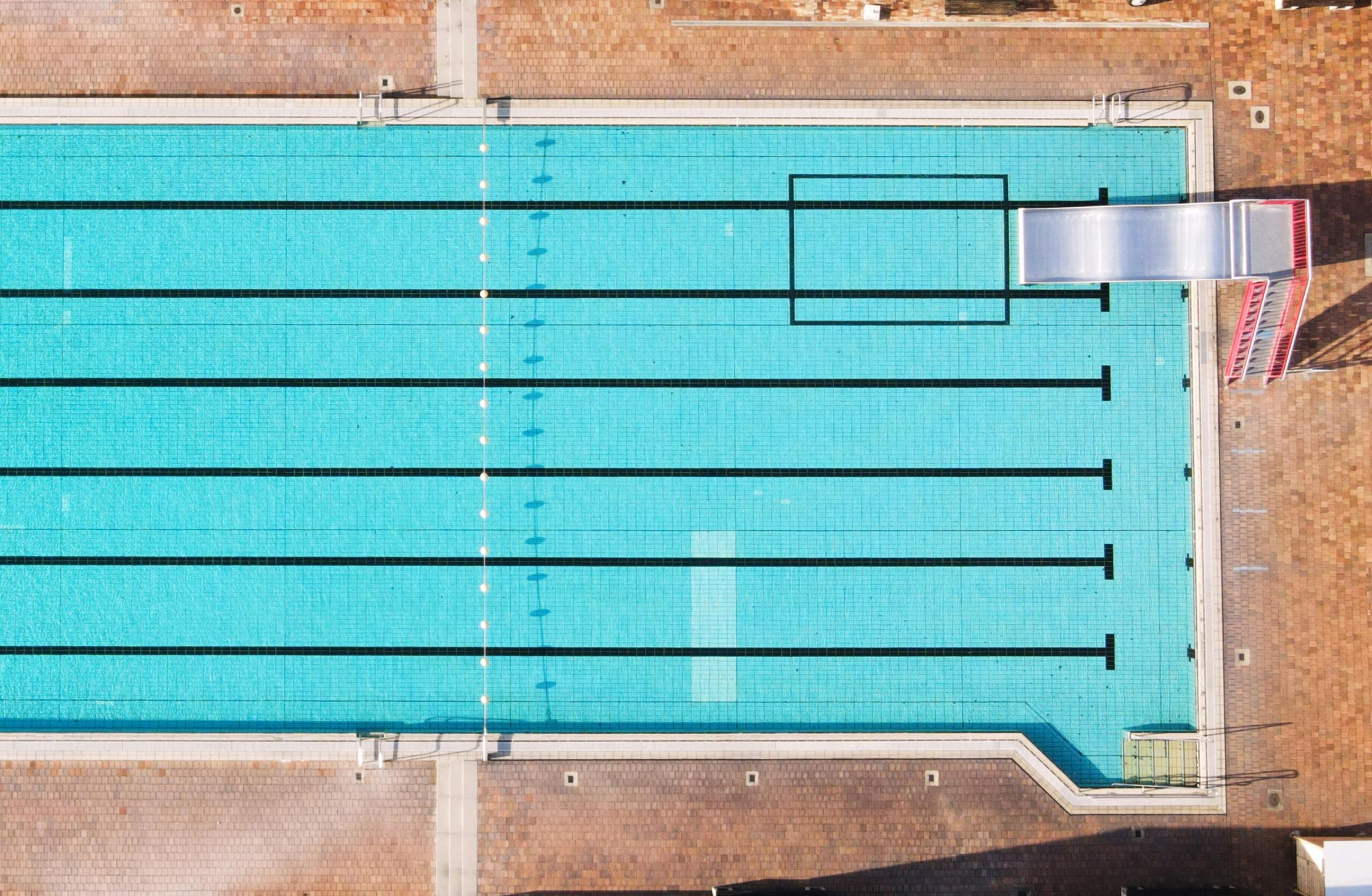 aerial view of an outdoor swimming pool with a diving board