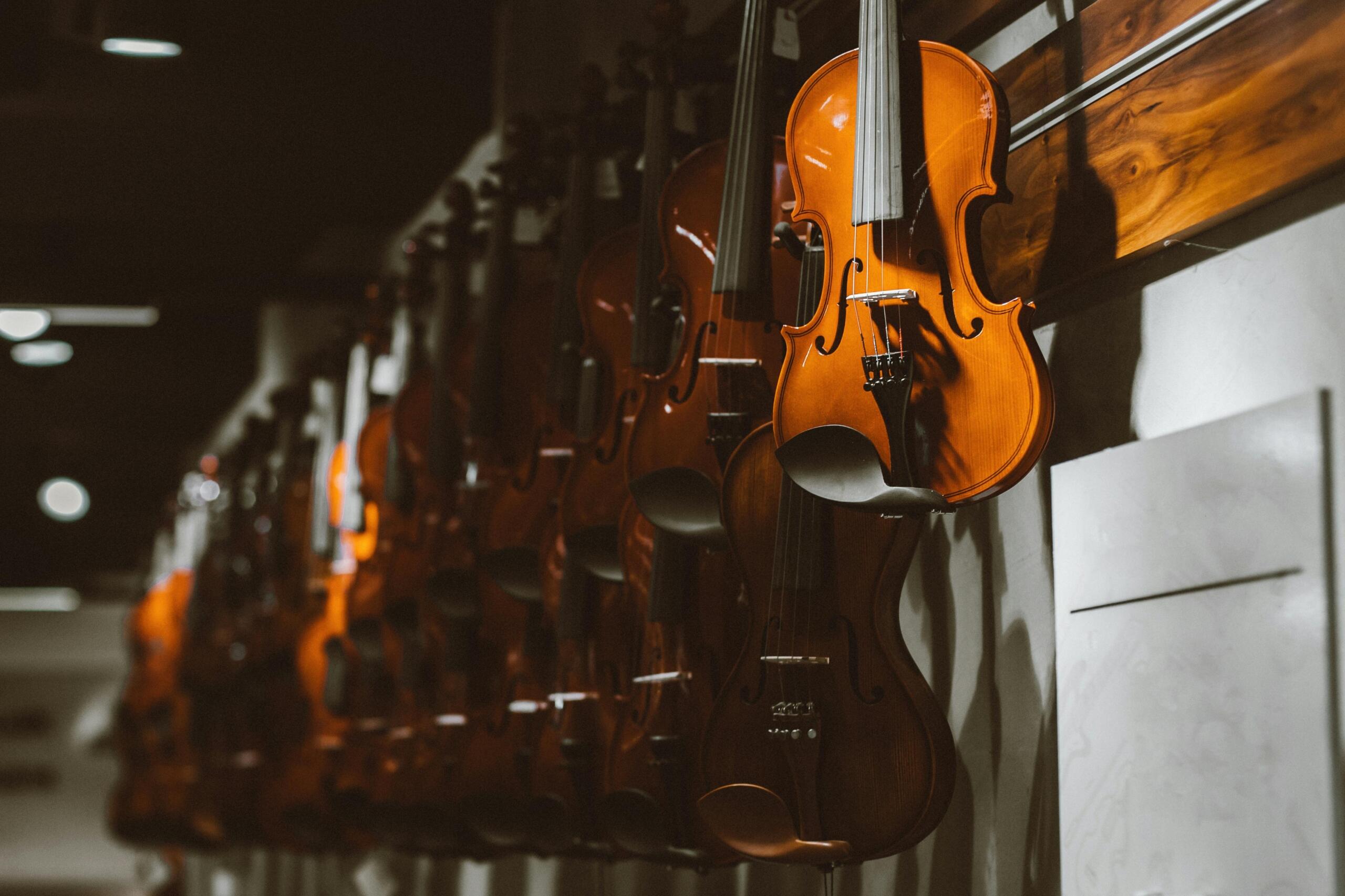 An image of violins hanging in a shop. 