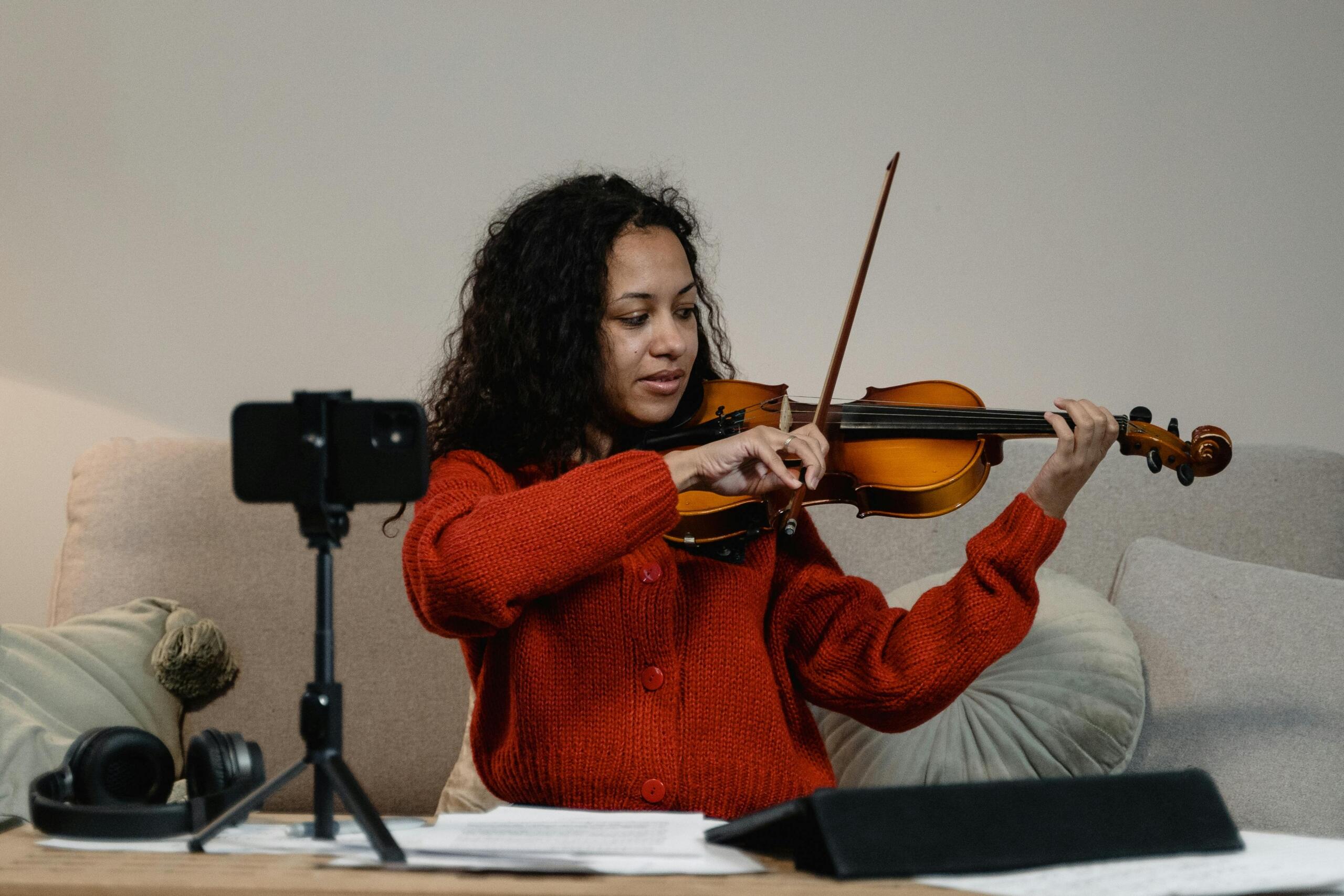 An image of a young music student filming her progress. 