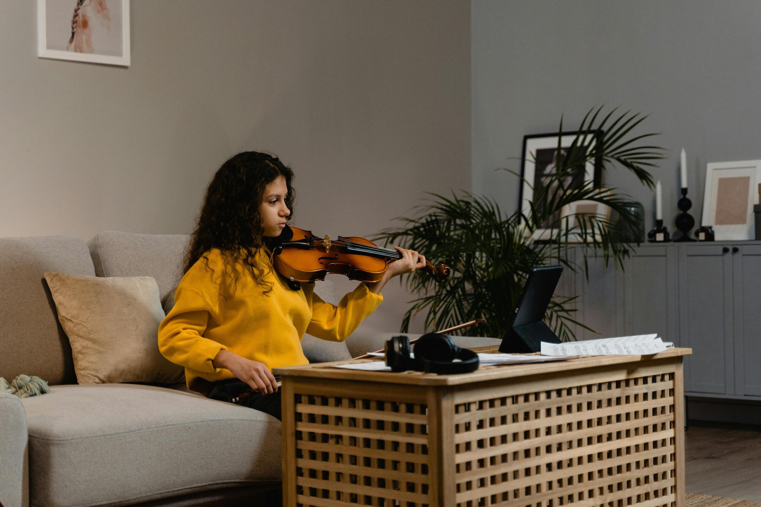 A young musician learns violin at home. 