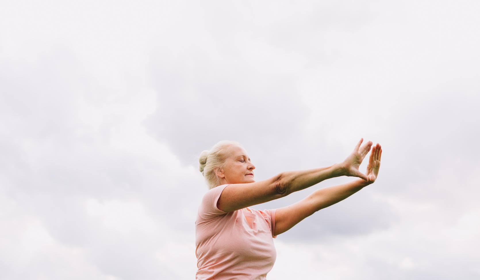 An image of a Tai Chi movement against a grey sky.