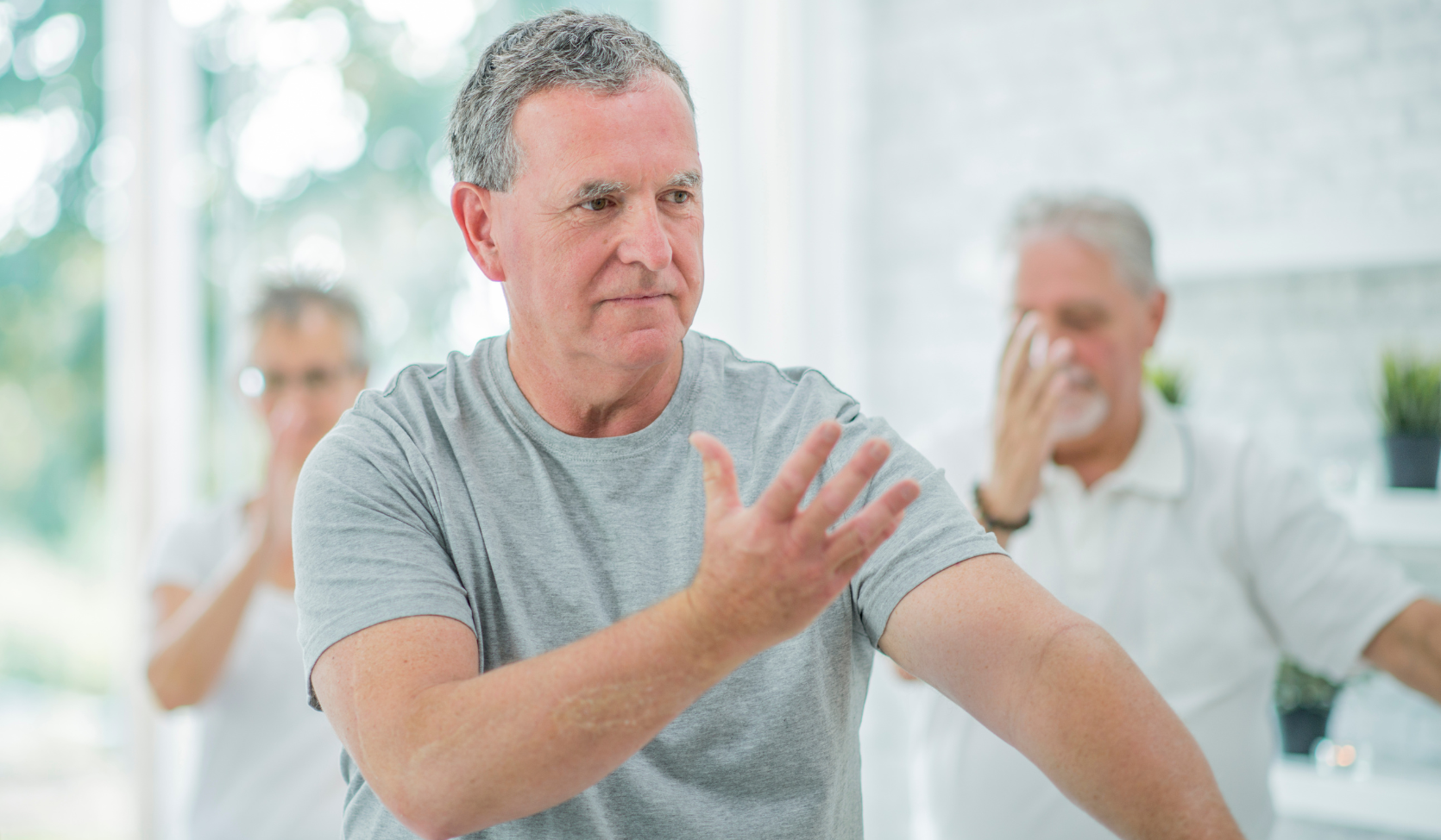a group of people doing tai chi indoors