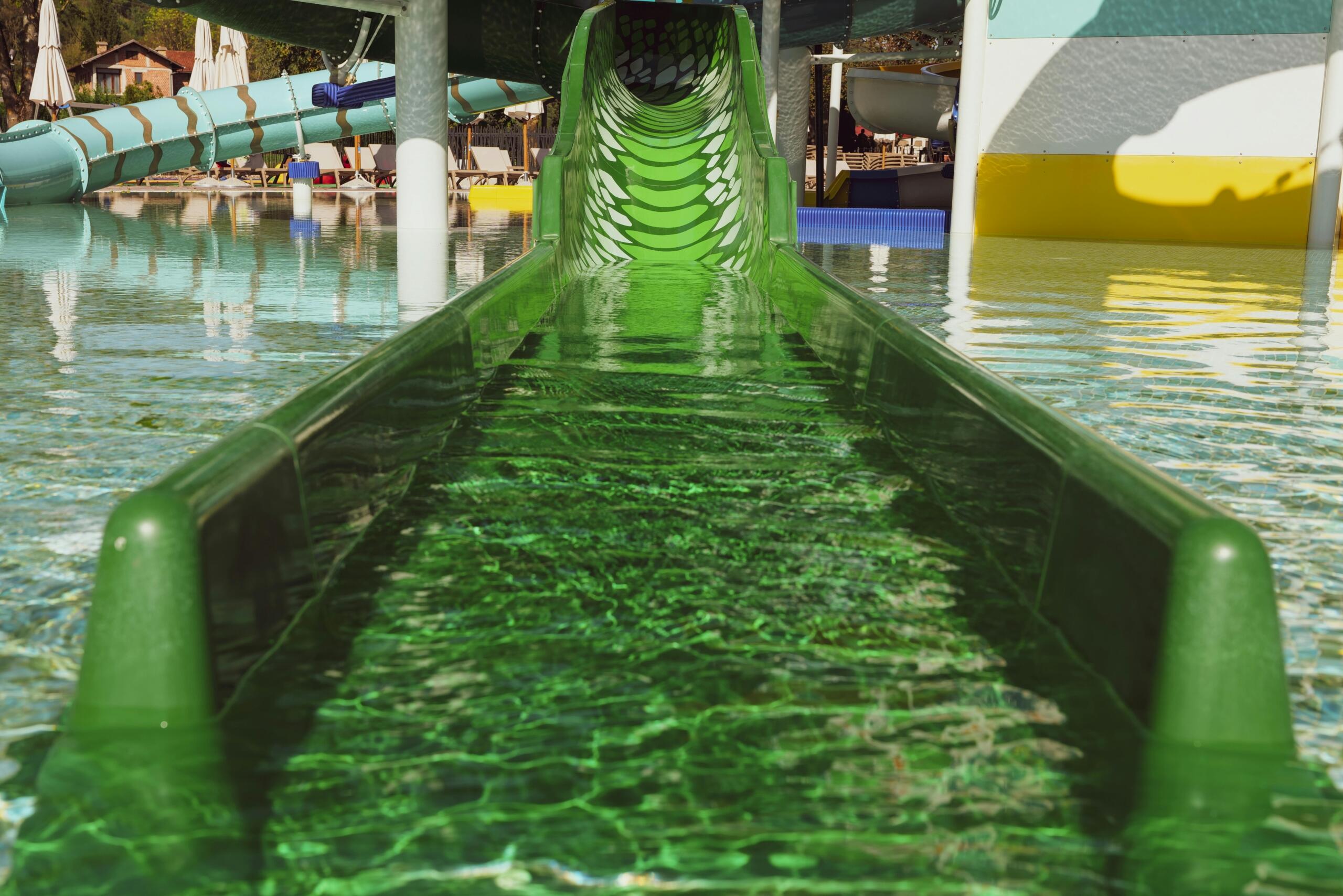 close up of an empty green water slide at an aqua park