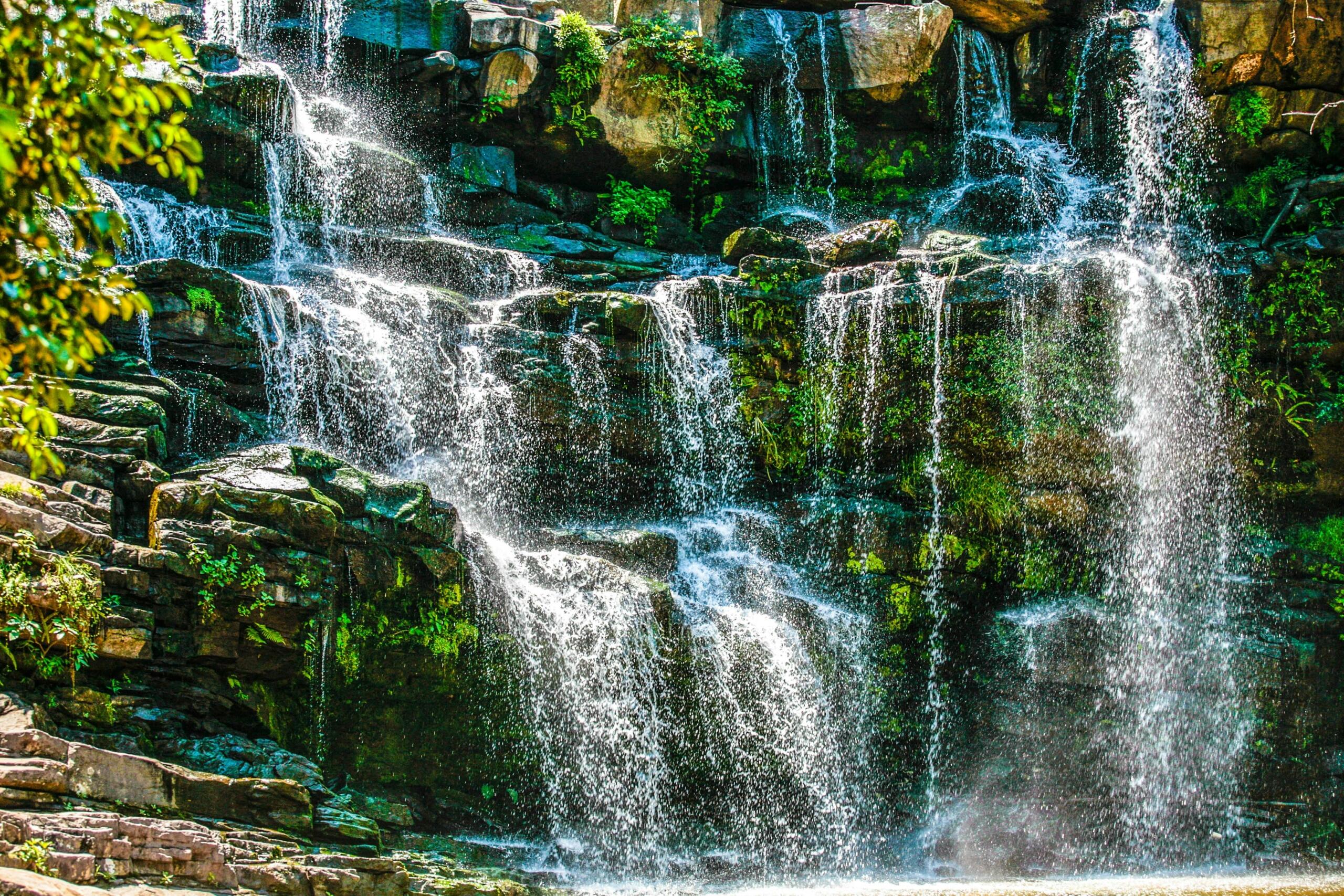 An image of a waterfall cascading over moss-covered rocks. 