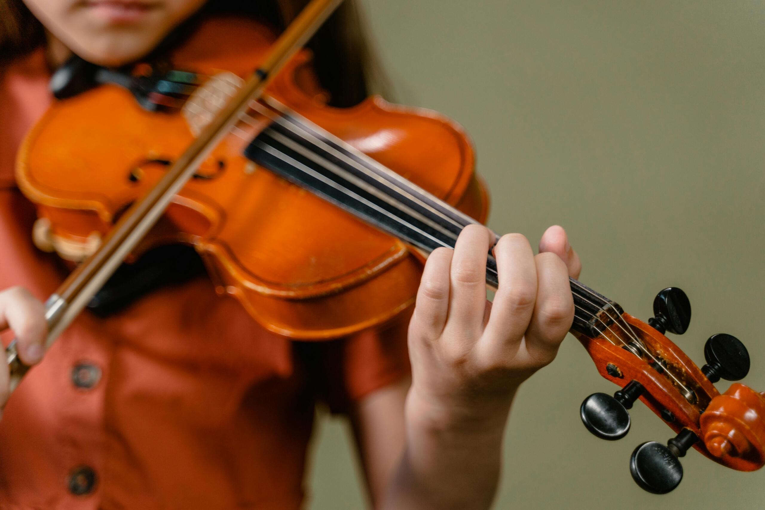 A close up image of a musician playing a violin.
