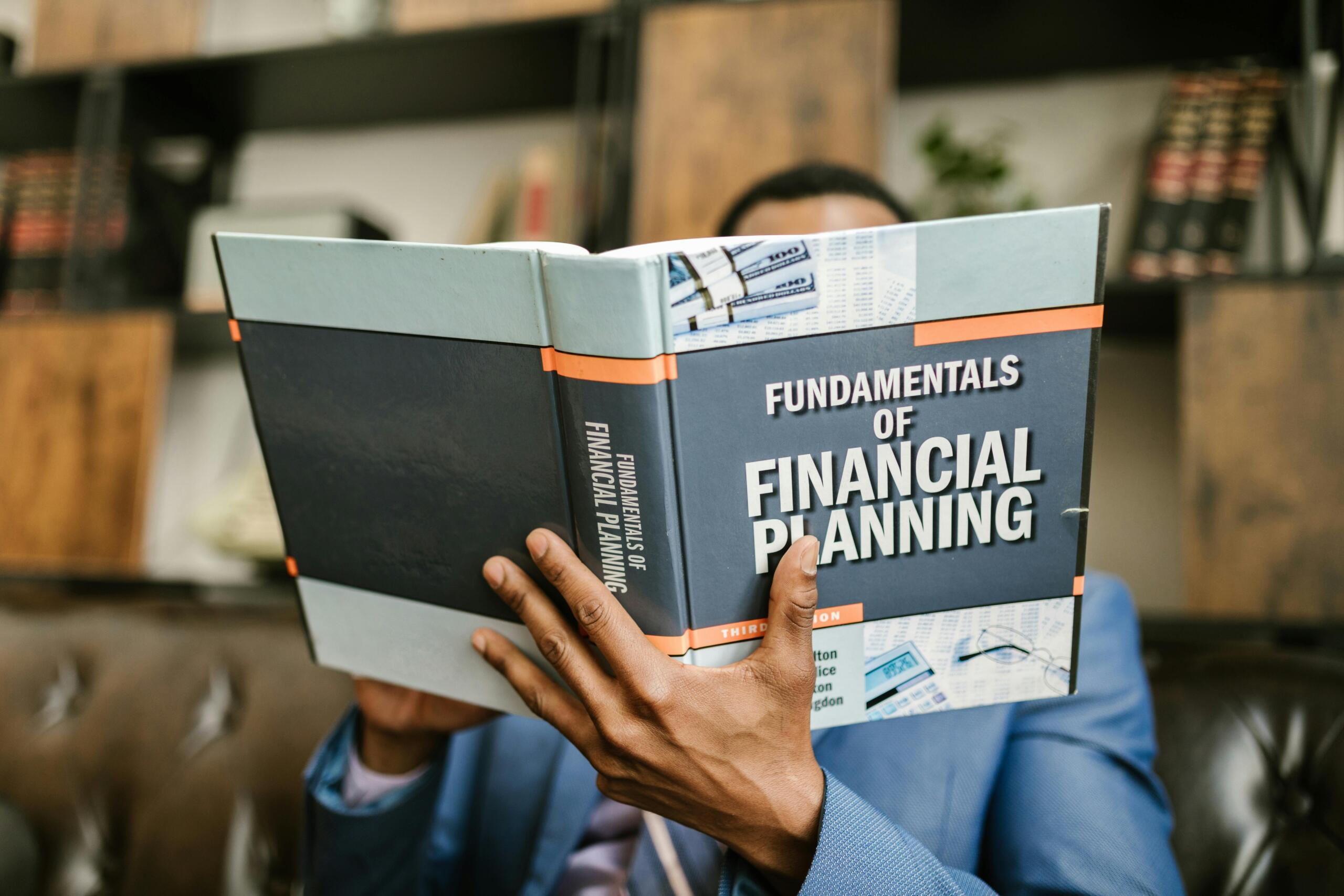 An image of a man reading a book about financial planning.