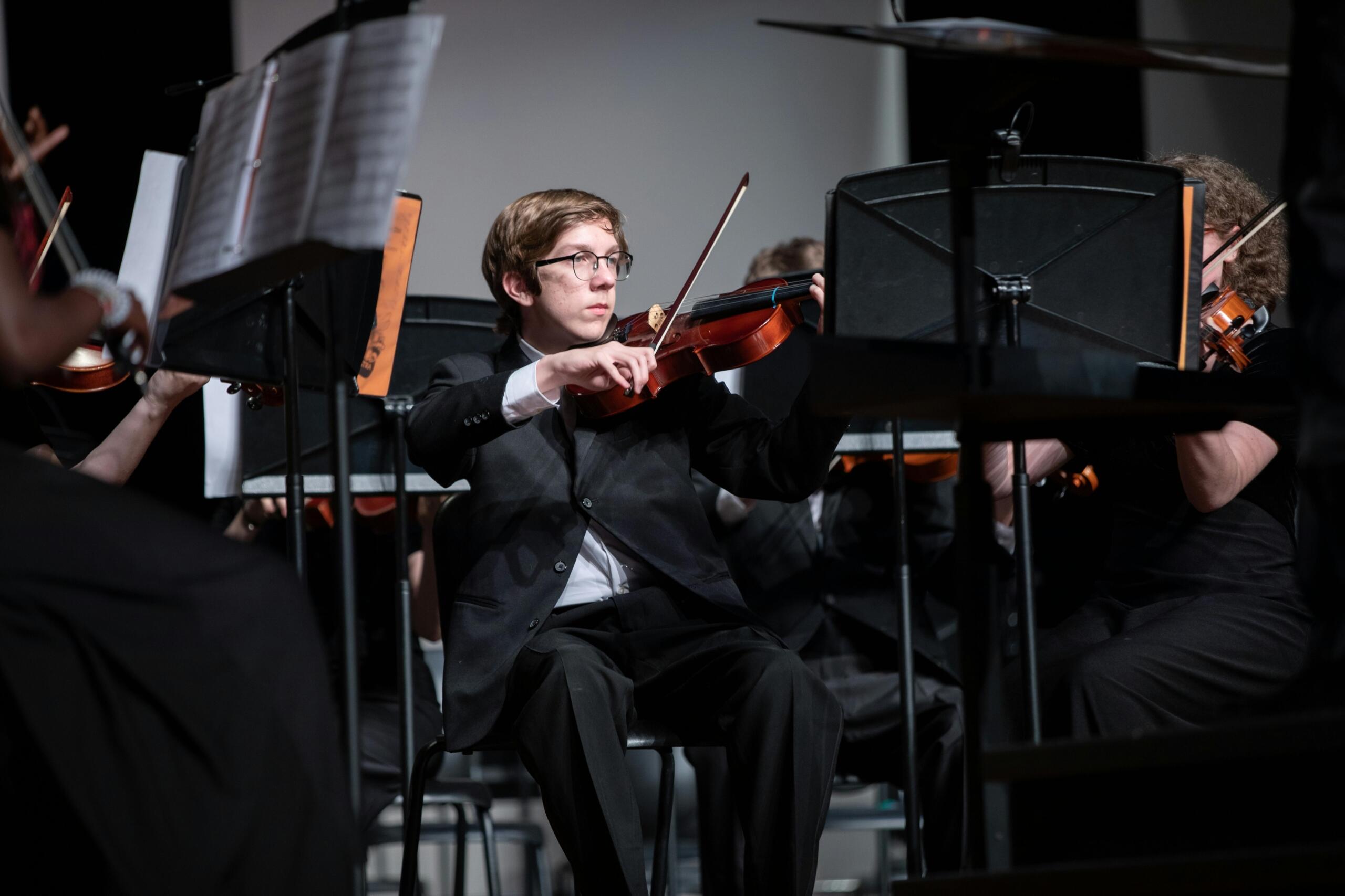 An image of a musician playing a violin piece. 