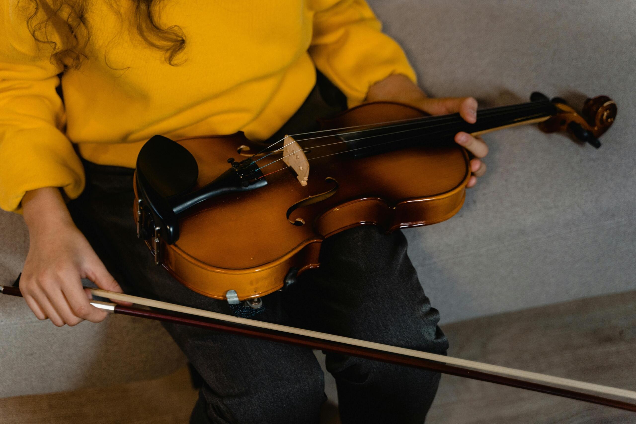 An image of a violin resting on a lap.