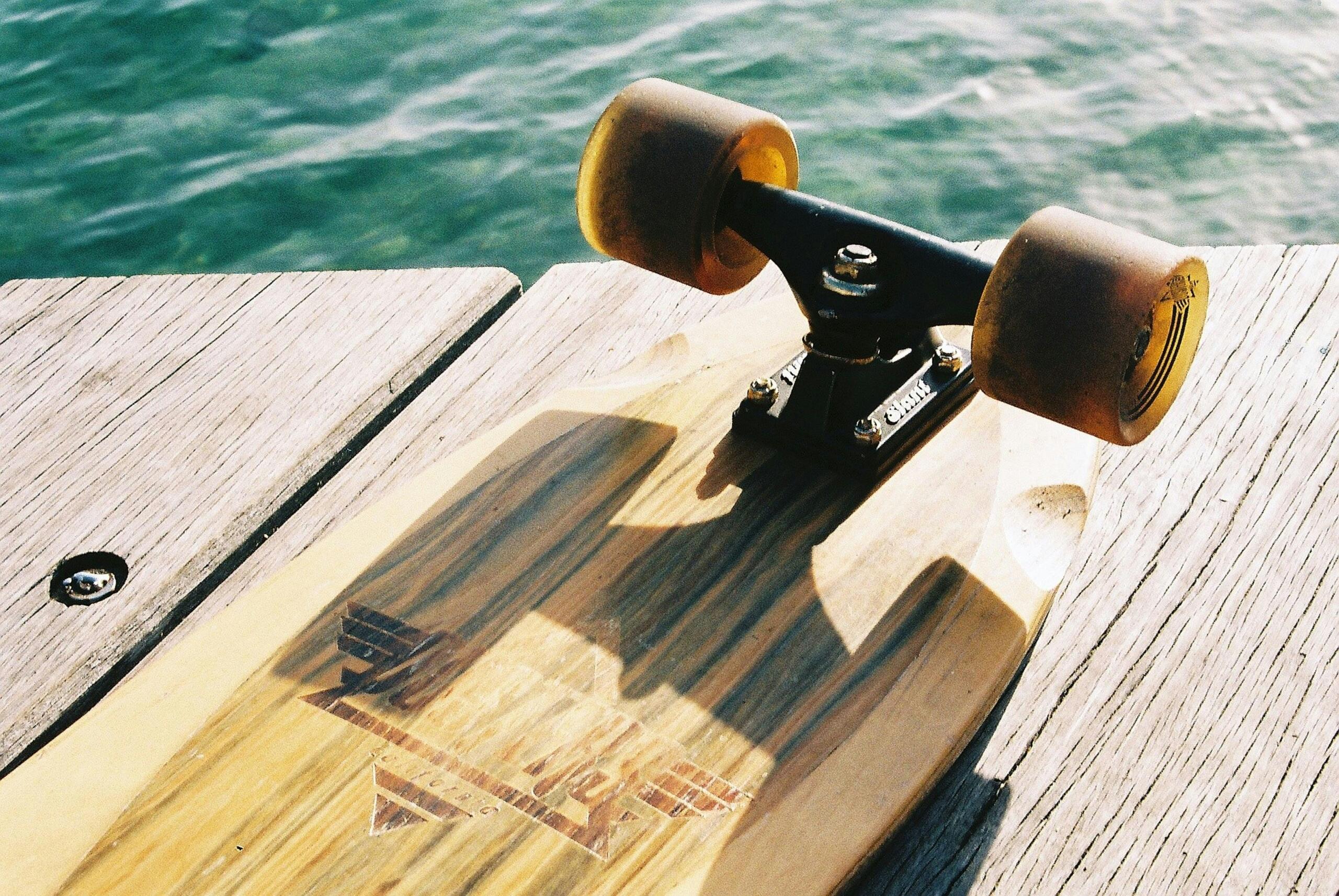 upside down skateboard on jetty near water's edge