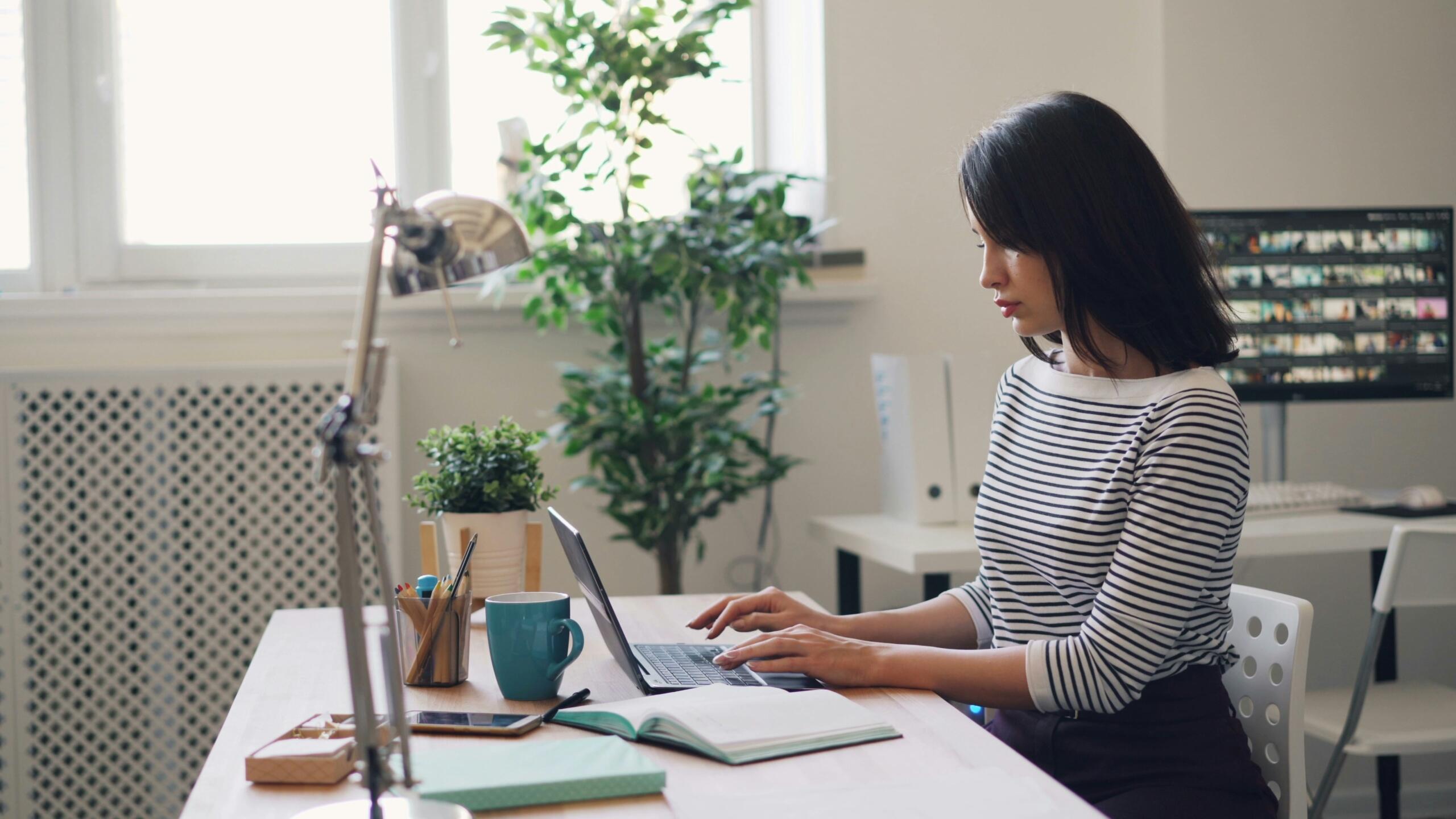 An image of a professional woman works at her desk.