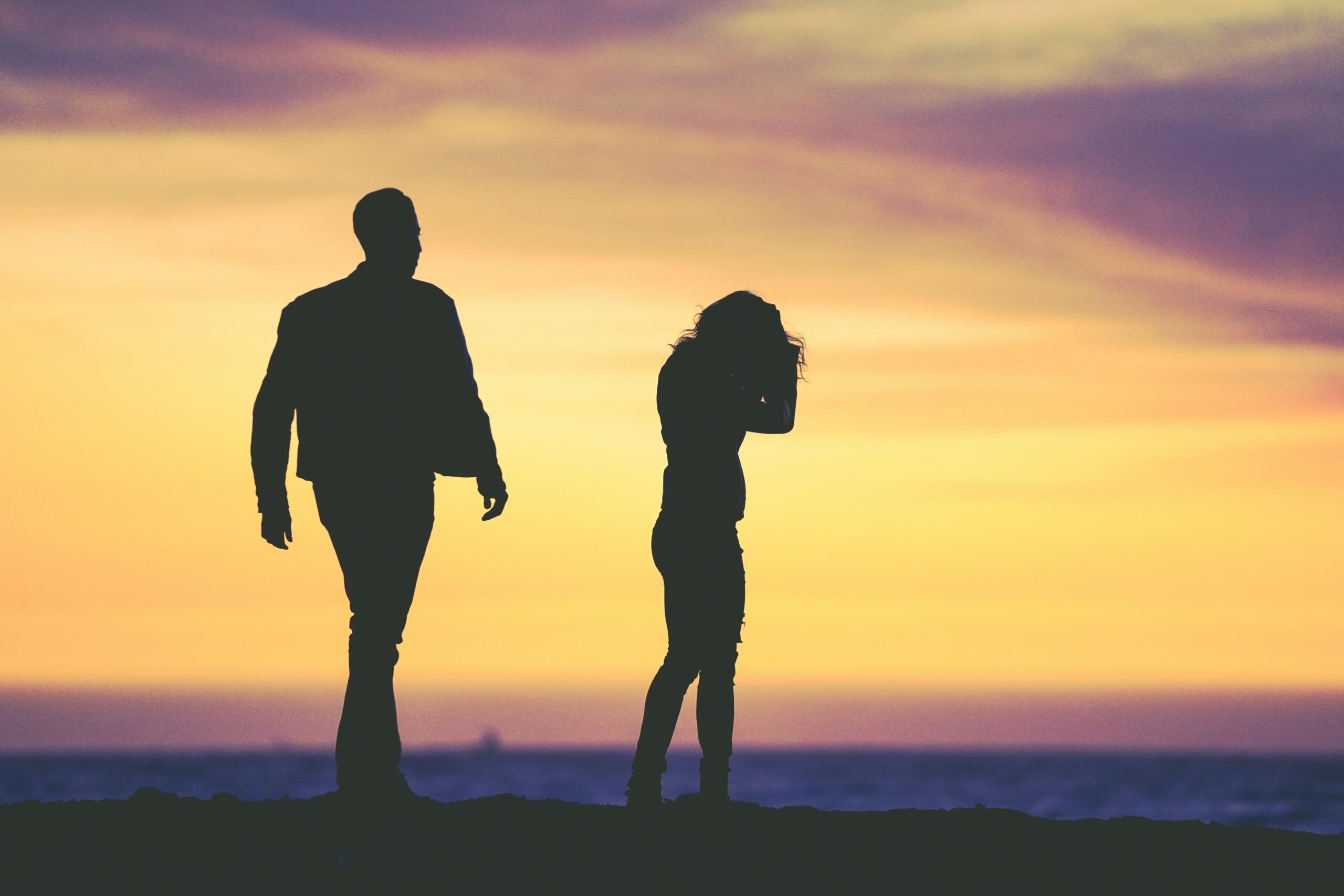An image of two people in silhouette who are not relating. 