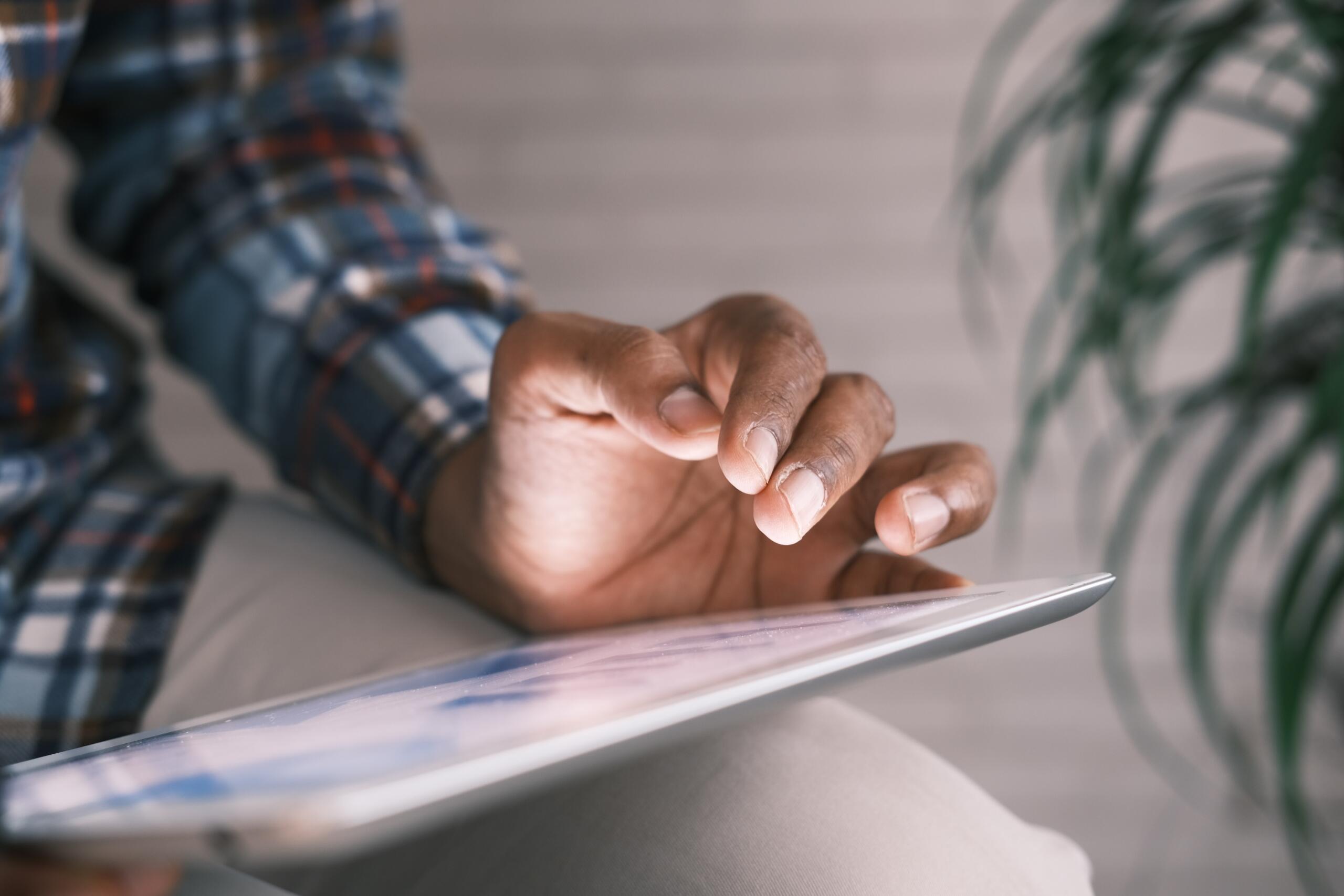 man sitting in a chair using an ipad