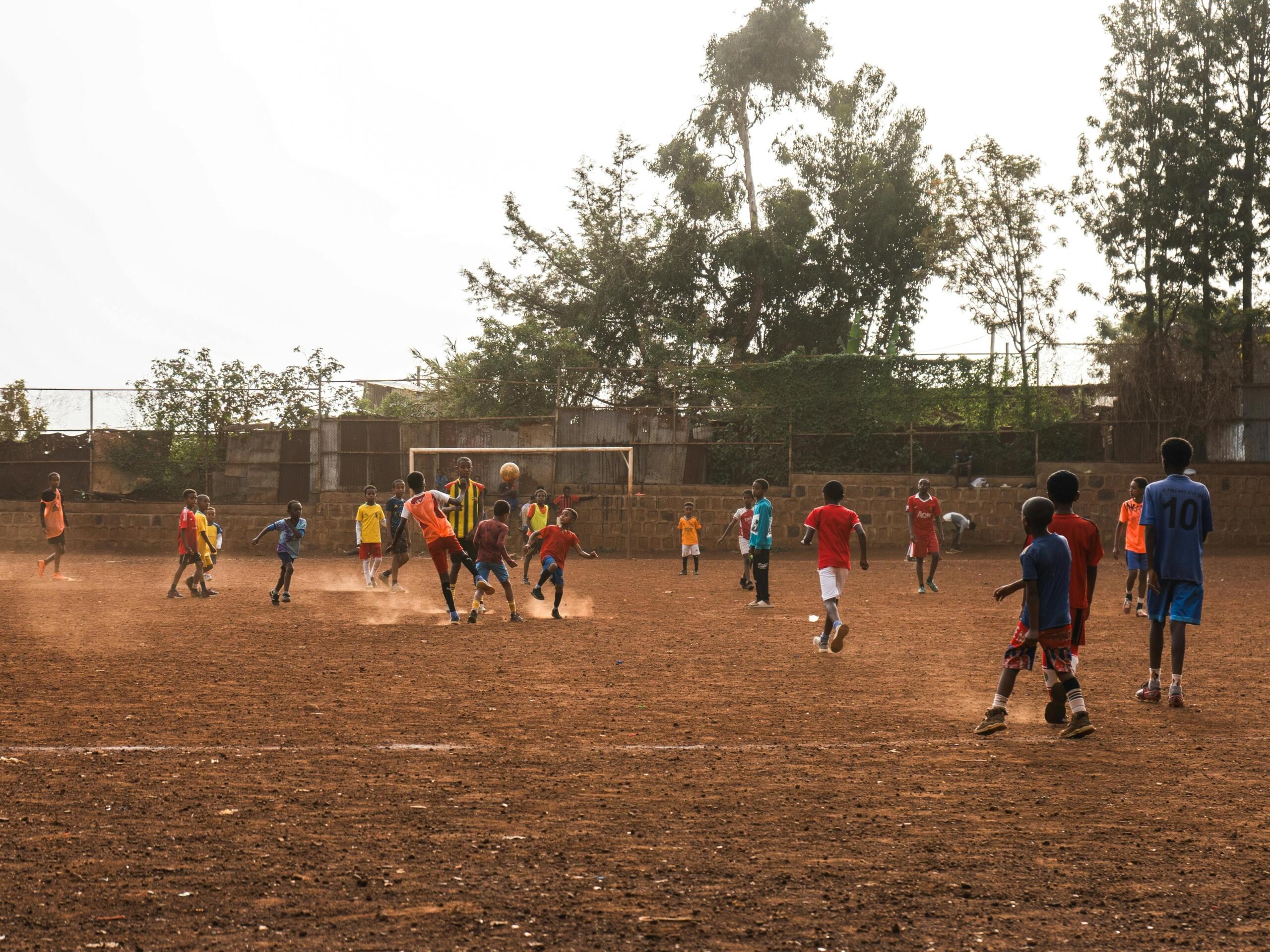 An image of soccer players playing in dust. 