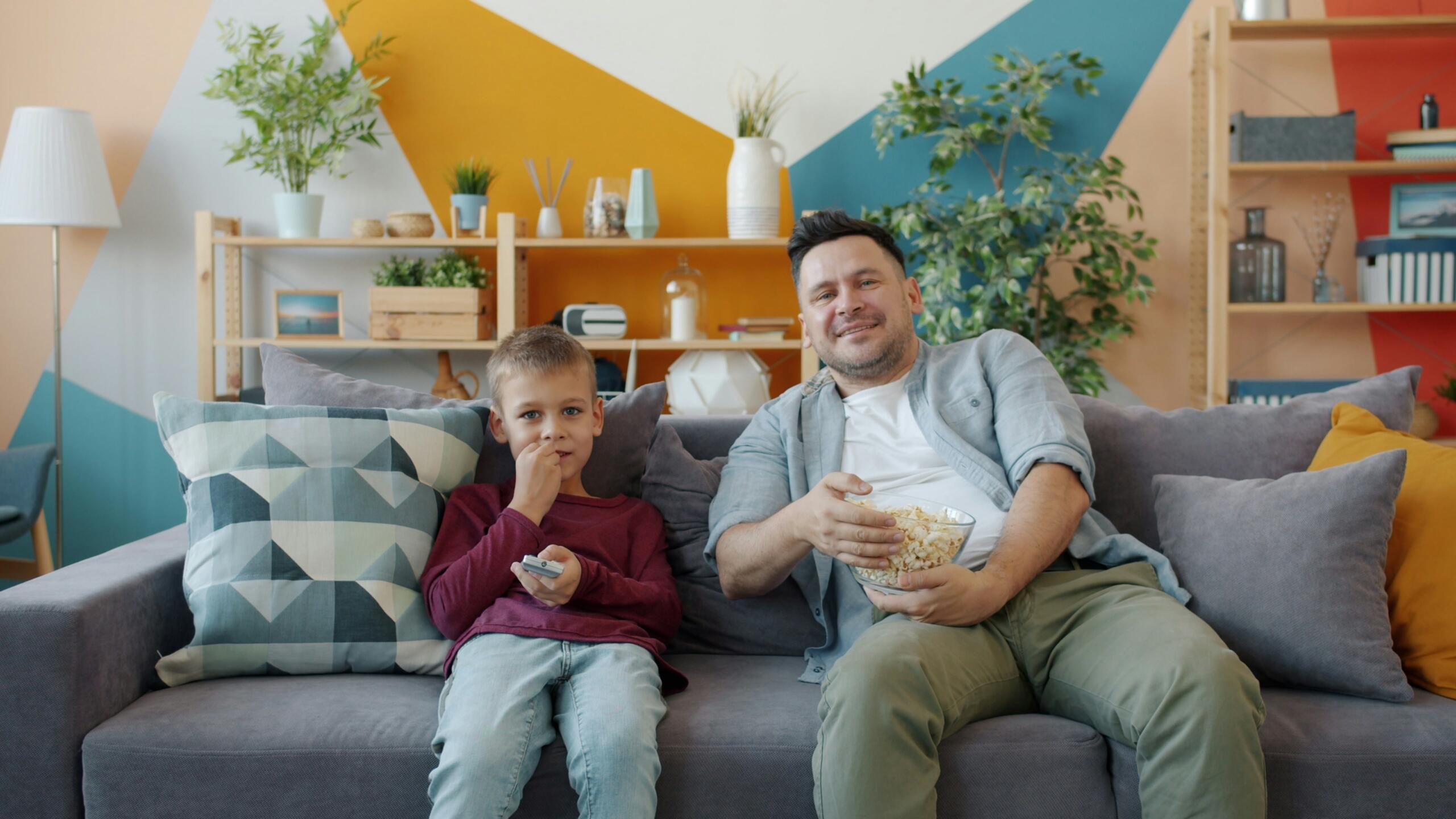 An image of a father and son watching TV.