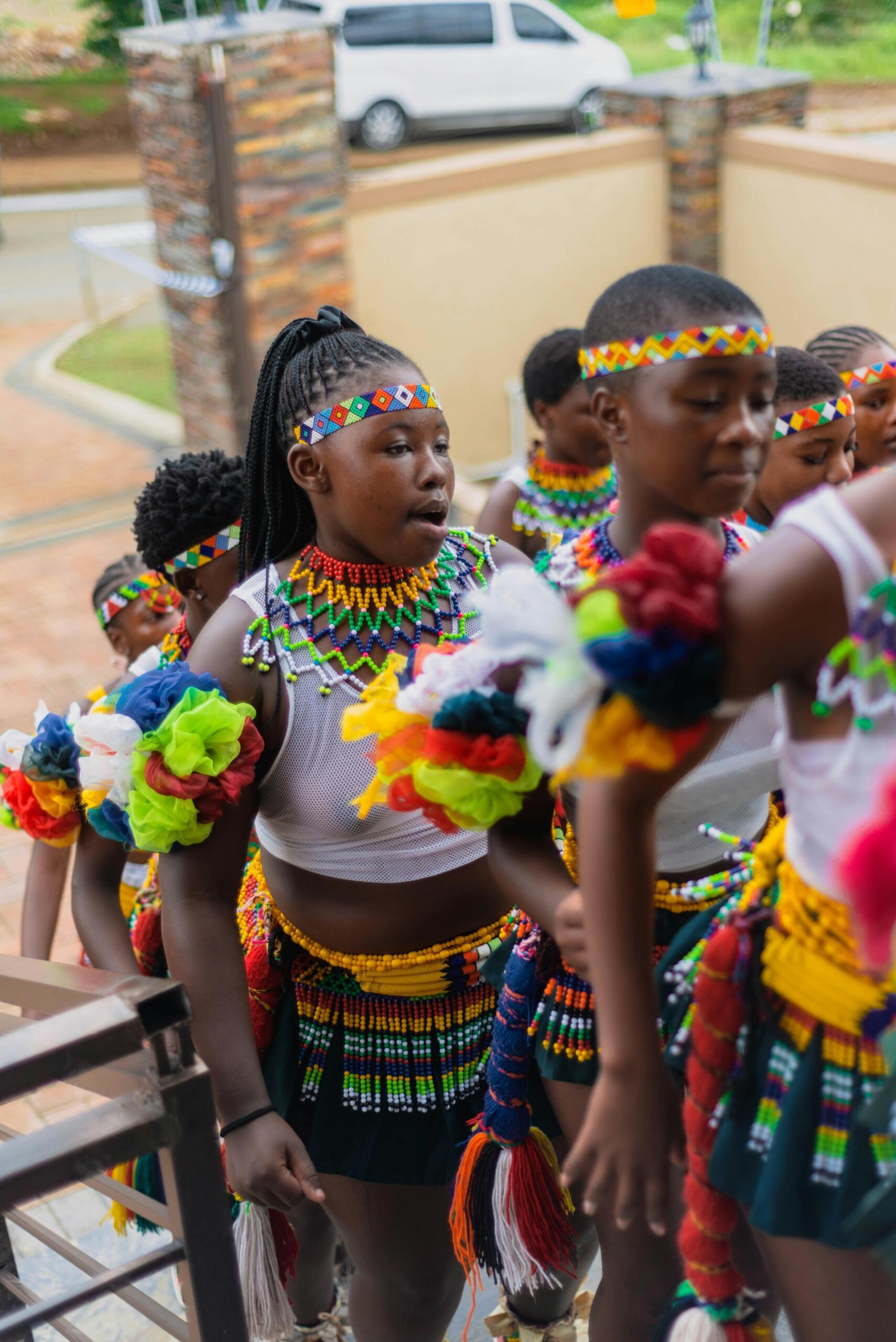 group of young Zulu traditional dancers walking up stairs