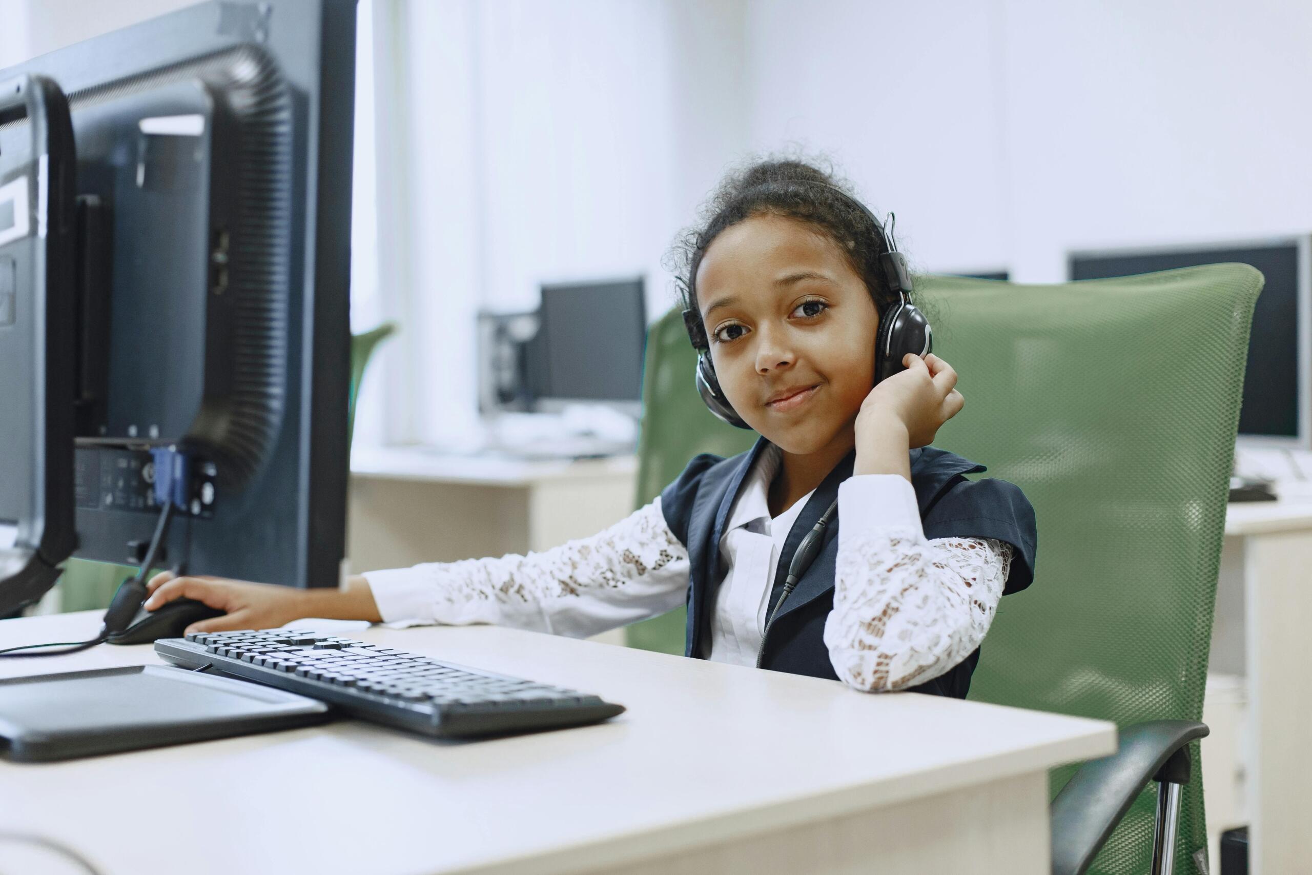 child sitting at a desk using a computer