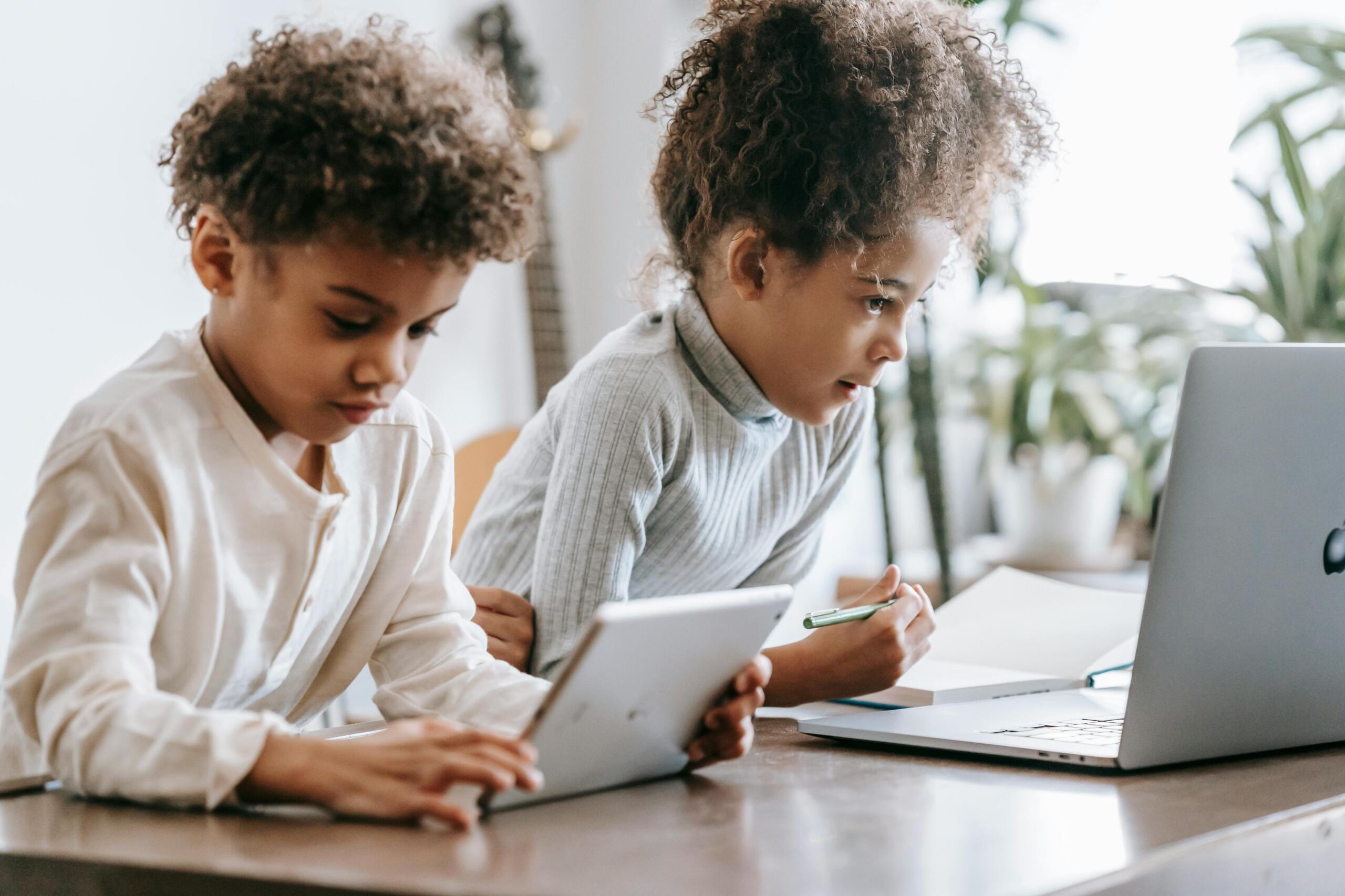 boy and girl sitting next to each other using digital devices