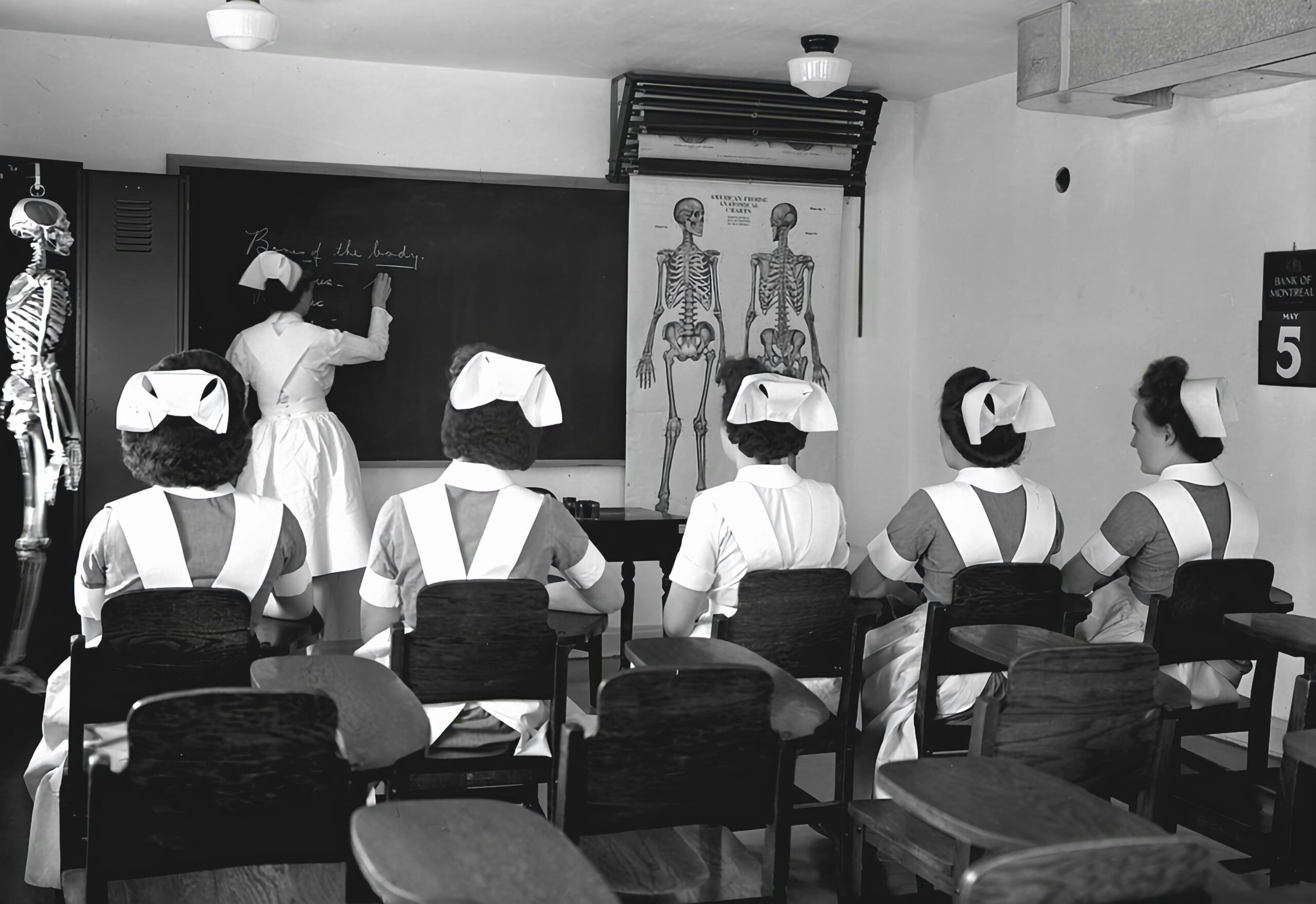 Nurses watching a head nurse demonstrate information on a whiteboard.